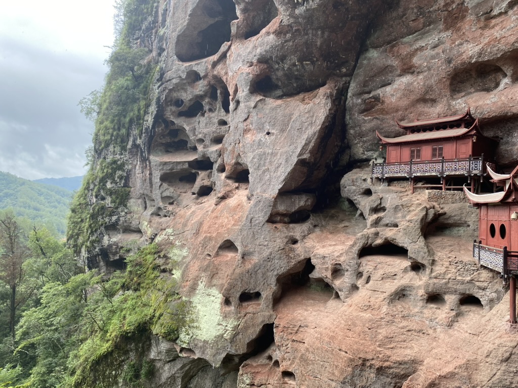 Temple Ganlu construit dans une falaise danxia à Taining, Fujian — murs de grès rouge surplombant les toits du temple