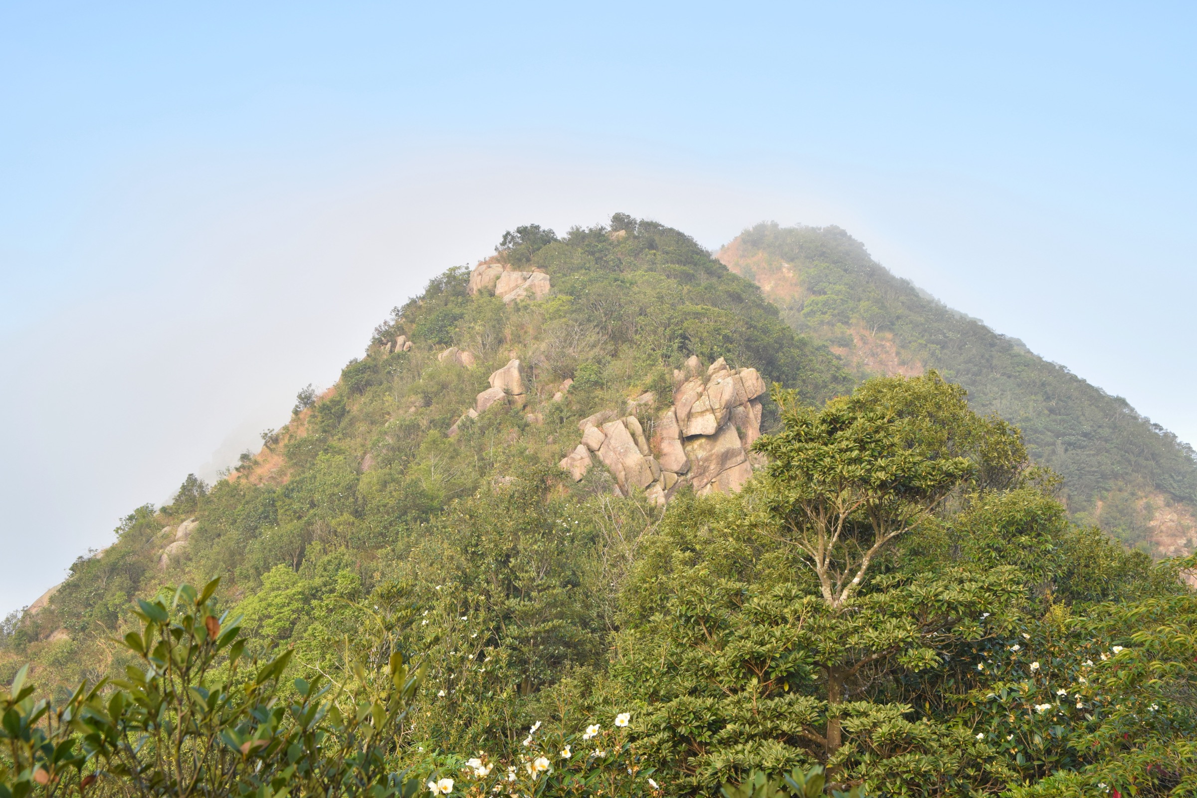 Hikers on the rocky summit ridge of Lion Rock above Kowloon, Hong Kong