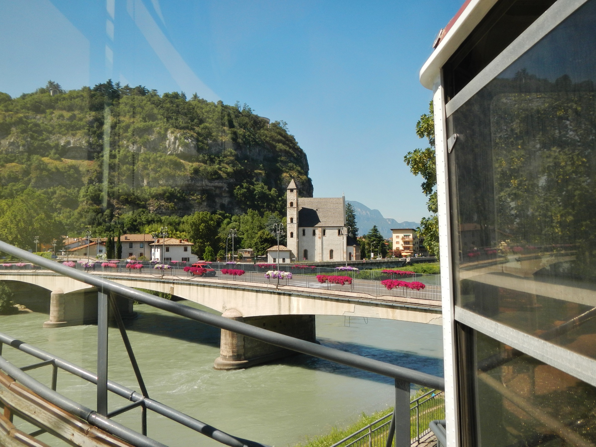 Le téléphérique Trente–Sardagna grimpant au-dessus de l'Adige avec le pont San Lorenzo et les toits de la ville en contrebas