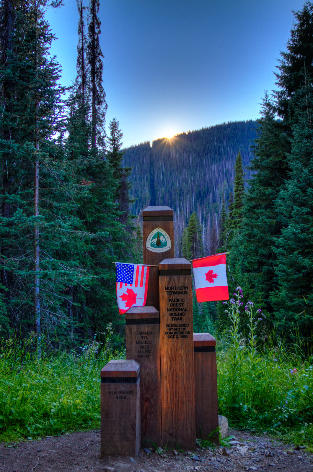 Le monument du terminus nord du PCT à la frontière USA–Canada au coucher du soleil