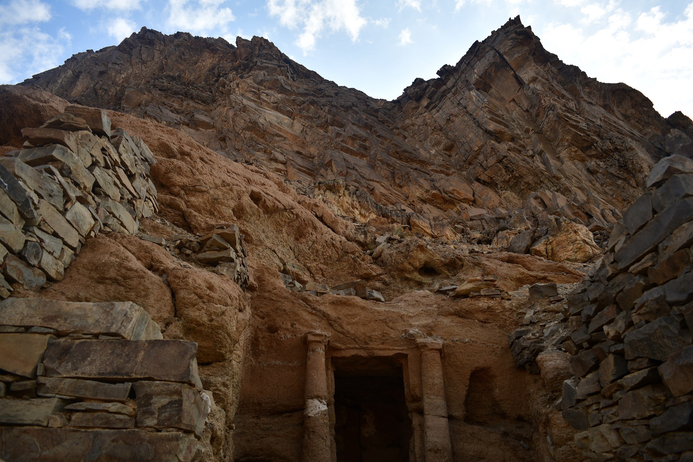Rock-cut temple at Sikait with jagged mountain backdrop in Egypt's Eastern Desert