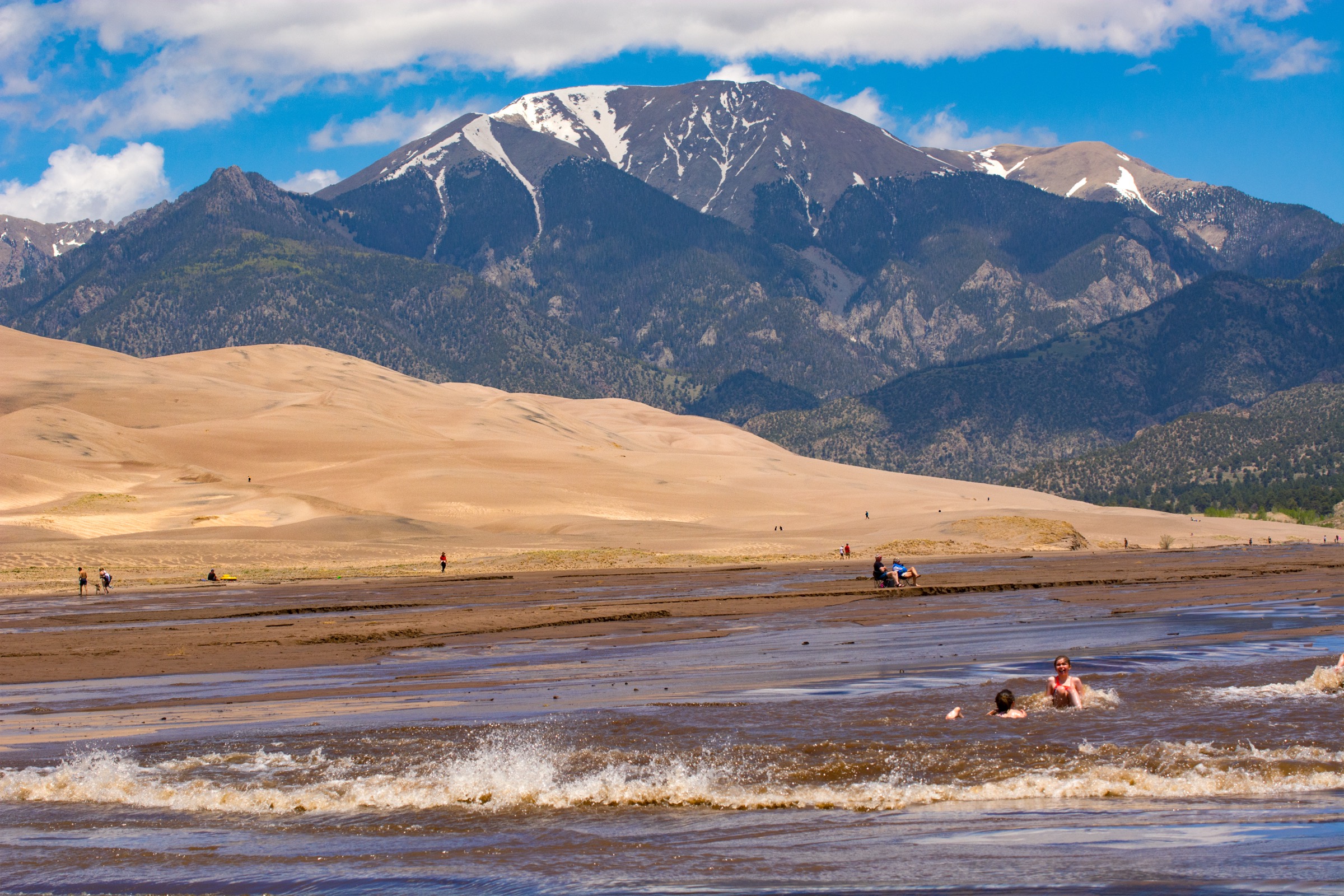 Medano Creek surge flow at the foot of the Great Sand Dunes with Mount Herard in the distance