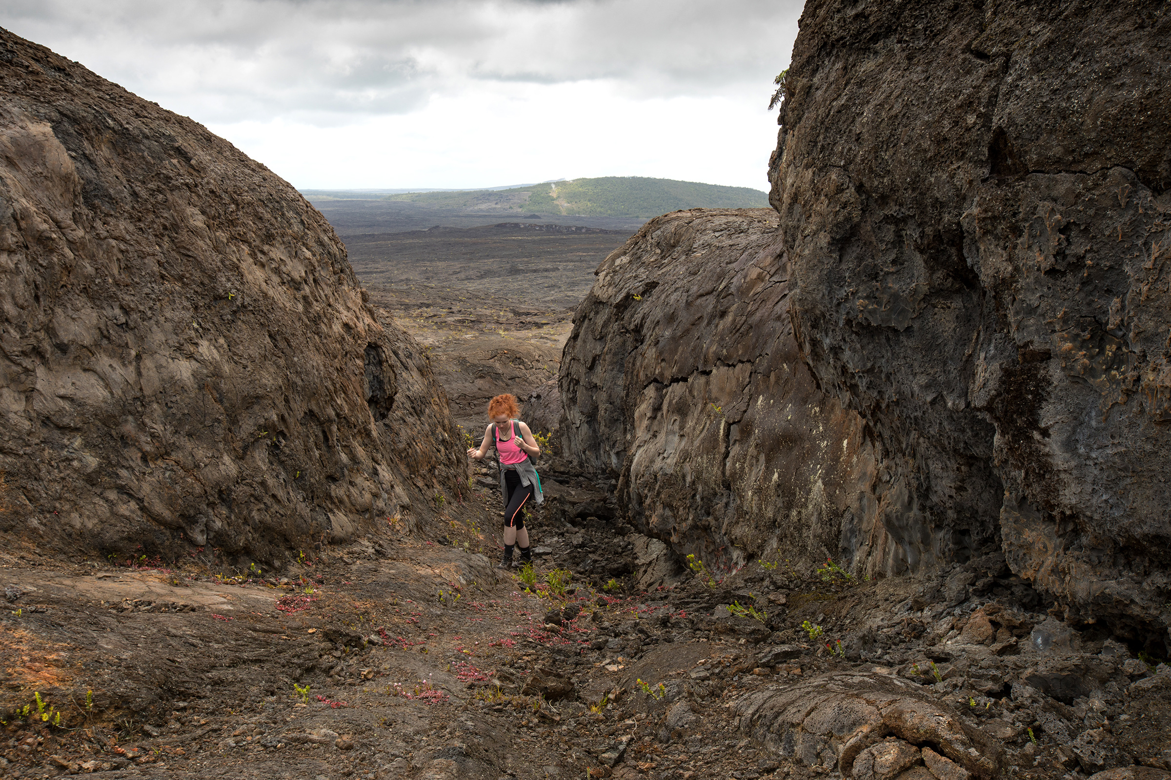 Hiker beside Maunaulu spatter ramparts on the Chain of Craters lava-flow landscape