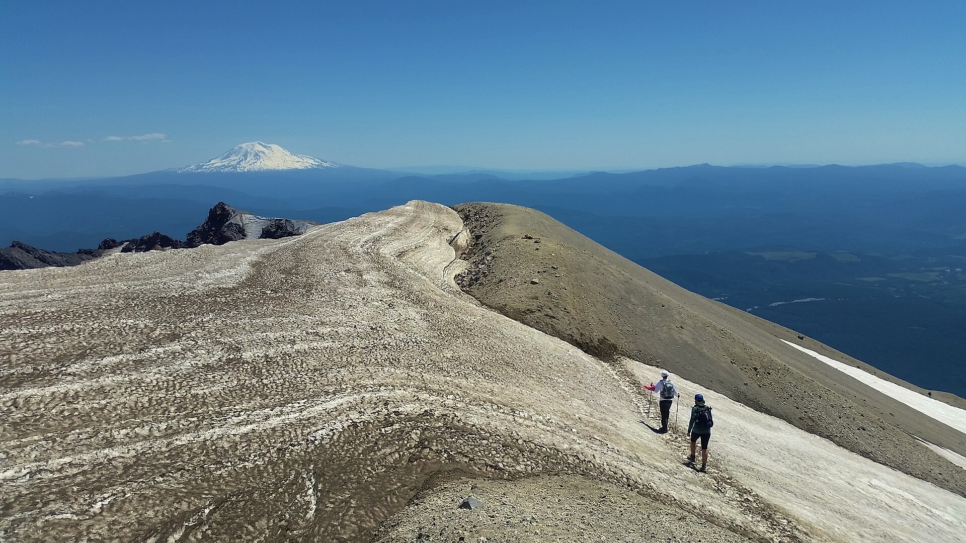 The crater rim of Mount St Helens with Mount Adams rising beyond