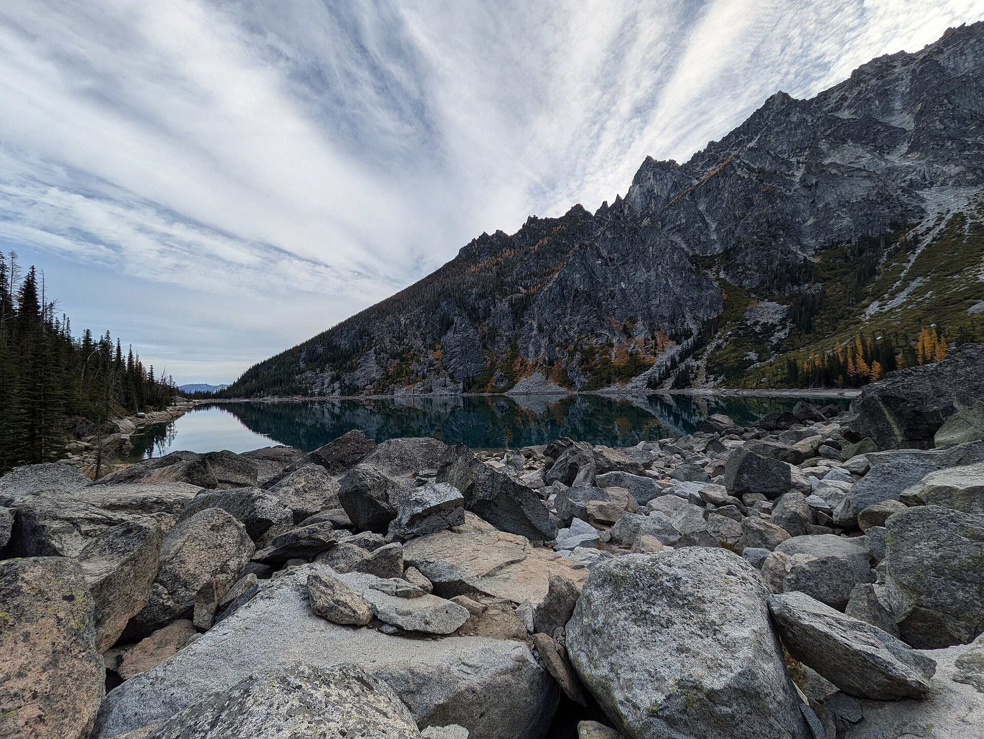 The turquoise water of Colchuck Lake below the dark wall of Dragontail Peak, Alpine Lakes Wilderness
