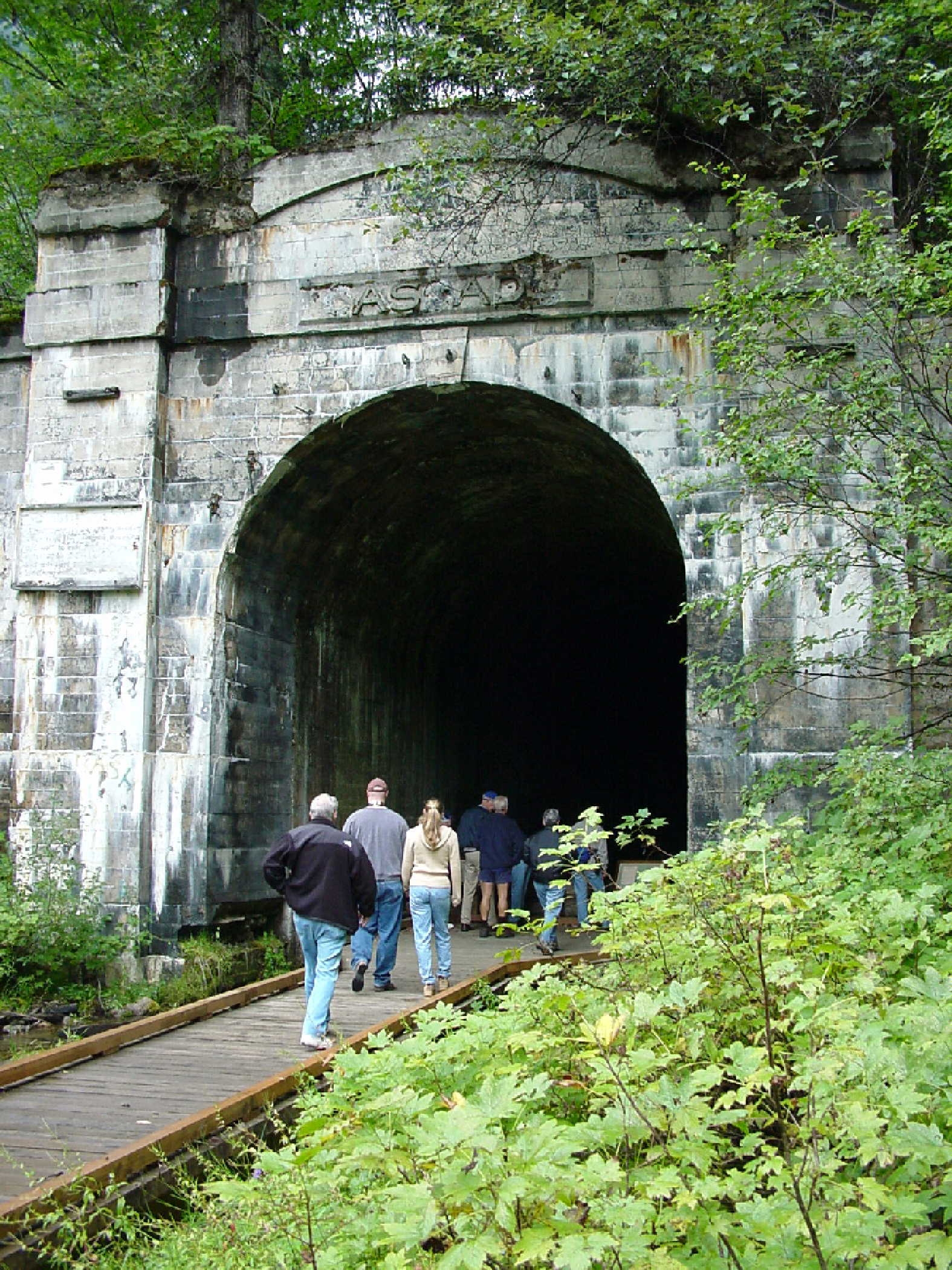 Walkers in a century-old Great Northern Railway tunnel on the Iron Goat Trail, Stevens Pass