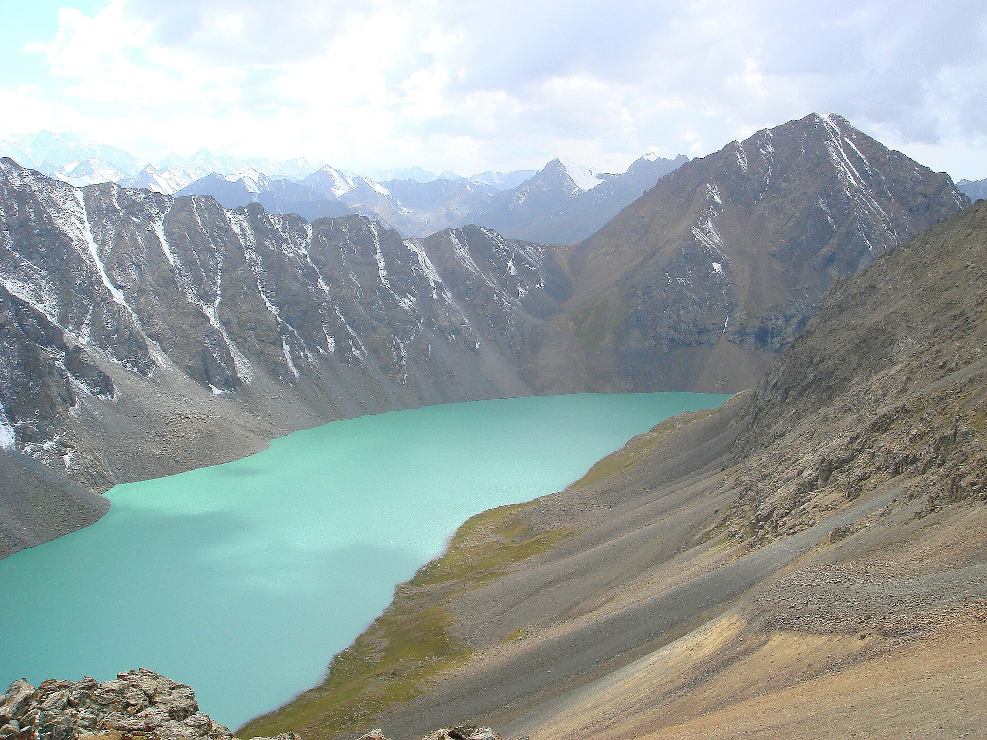 Turquoise Ala-Kul lake enclosed by steep Tian Shan ridges