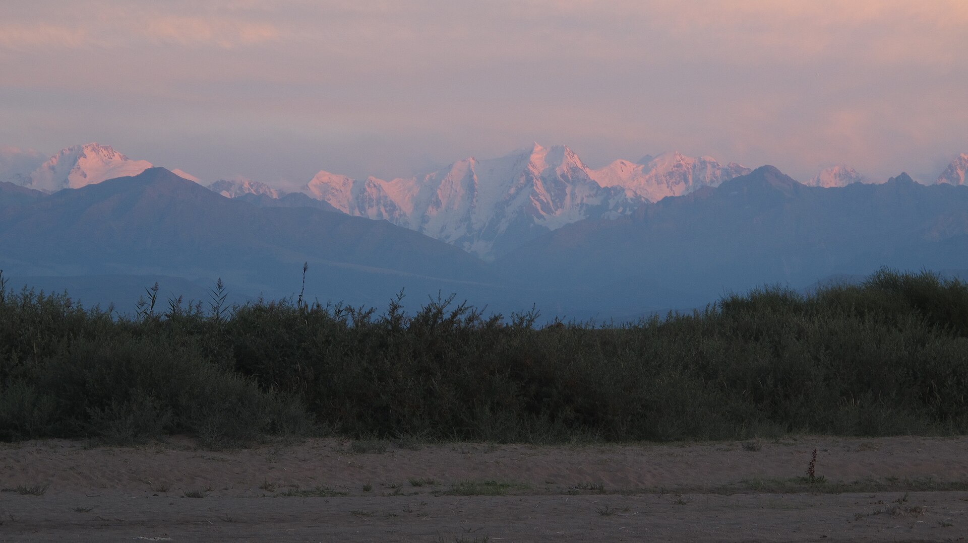 The snow-covered Terskey Ala-Too extending above Lake Issyk-Kul