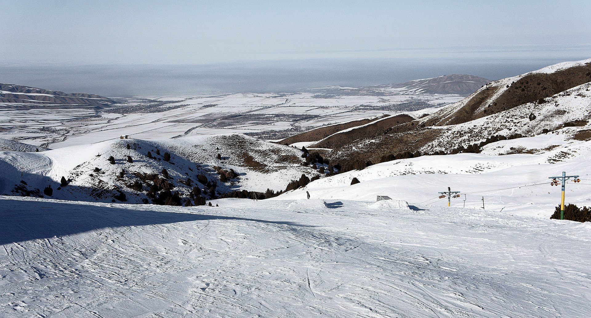 A skier descending open snow in the mountains of Kyrgyzstan