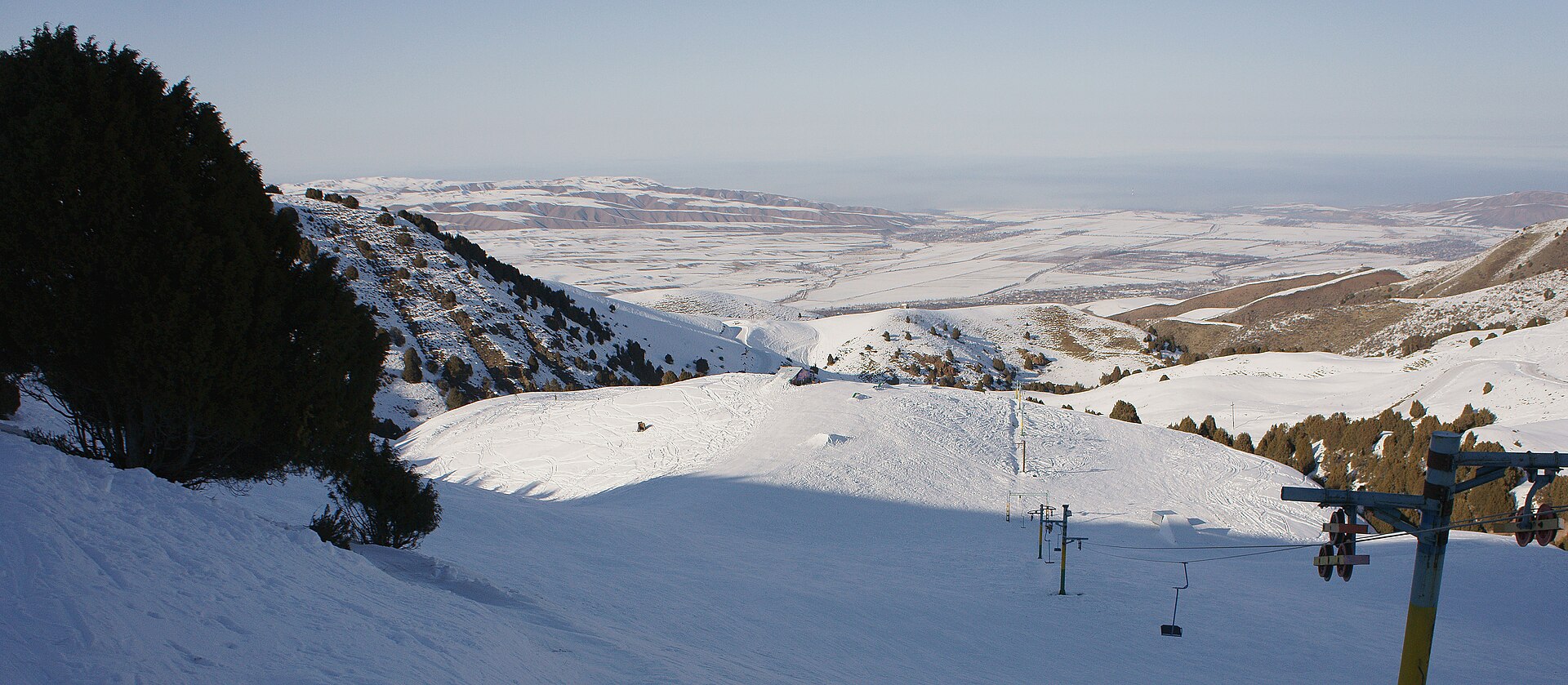 Skiers moving through a snowy high-mountain landscape in Kyrgyzstan