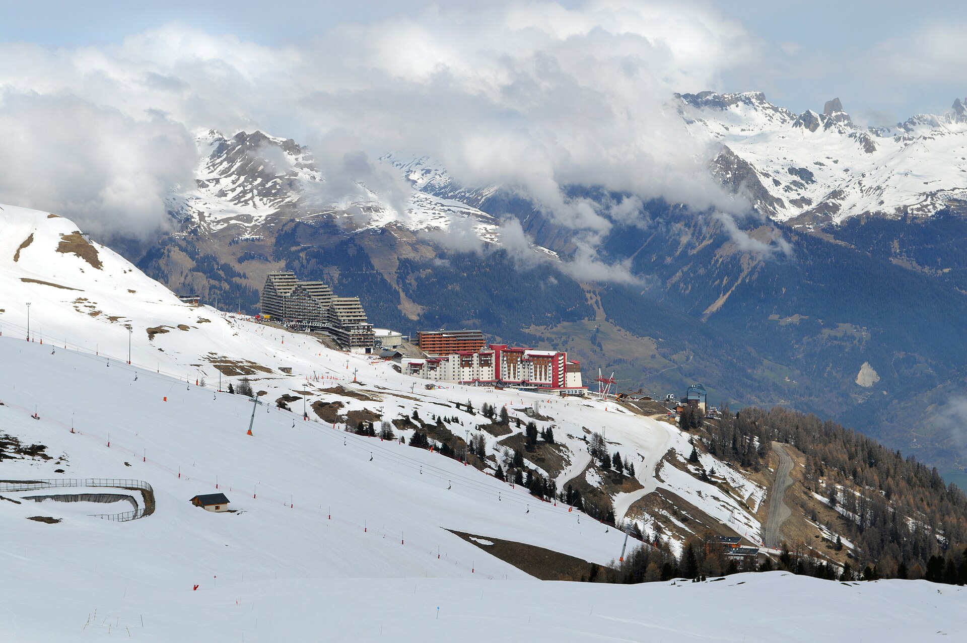 Snowy slopes and buildings at Aime La Plagne beneath low cloud