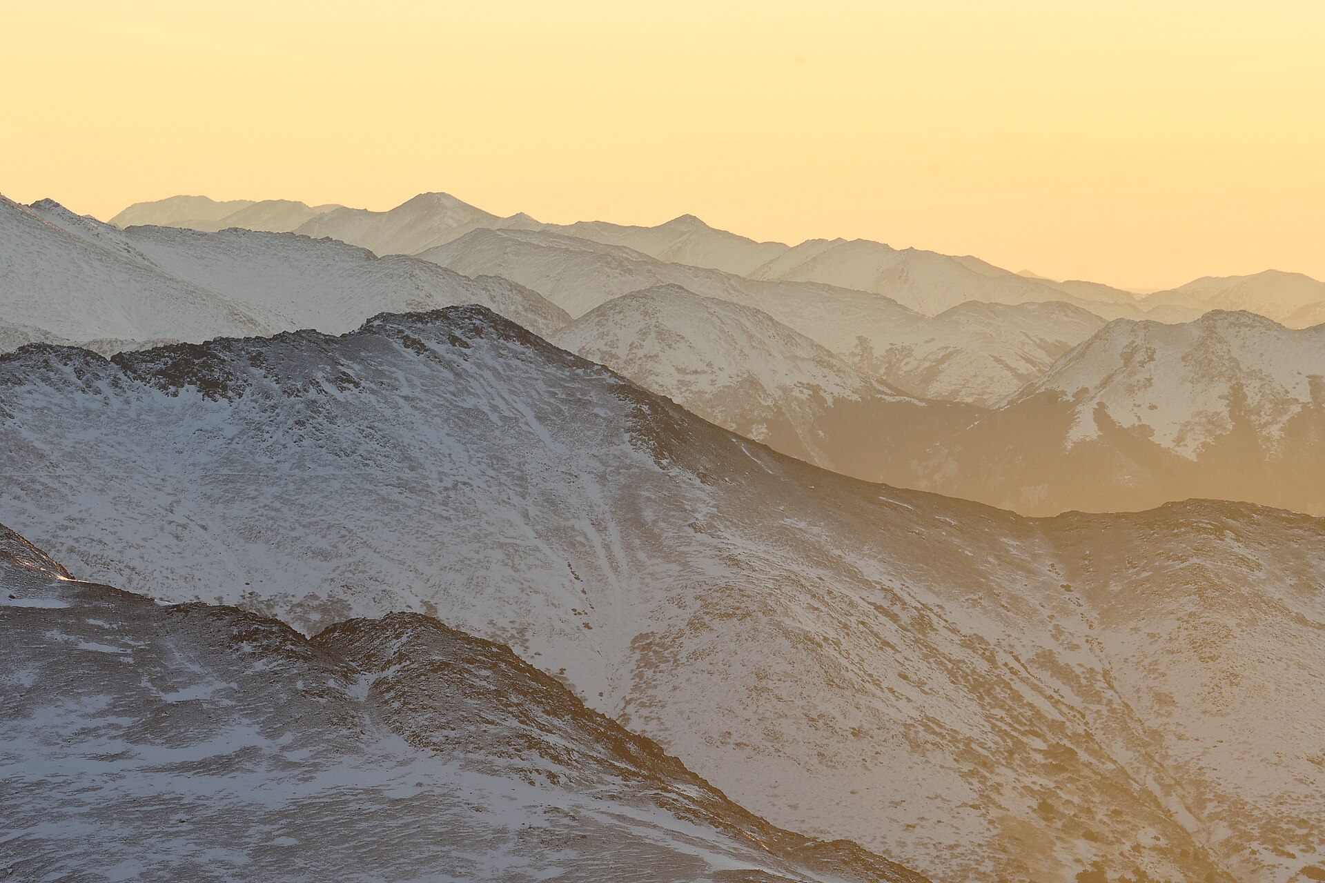 Snow-covered Chugach Mountains receding into warm early-winter light
