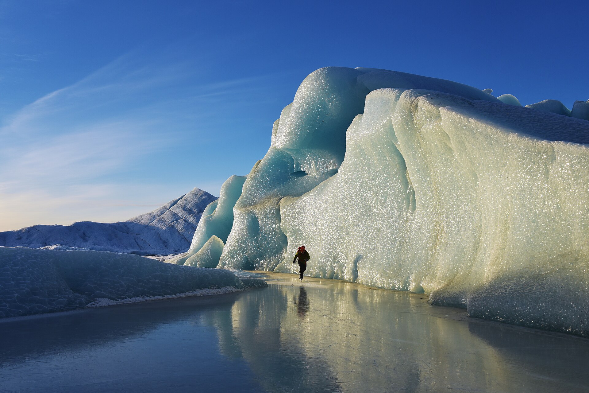 A person beside blue ice on a frozen lake at Sheridan Glacier near Cordova