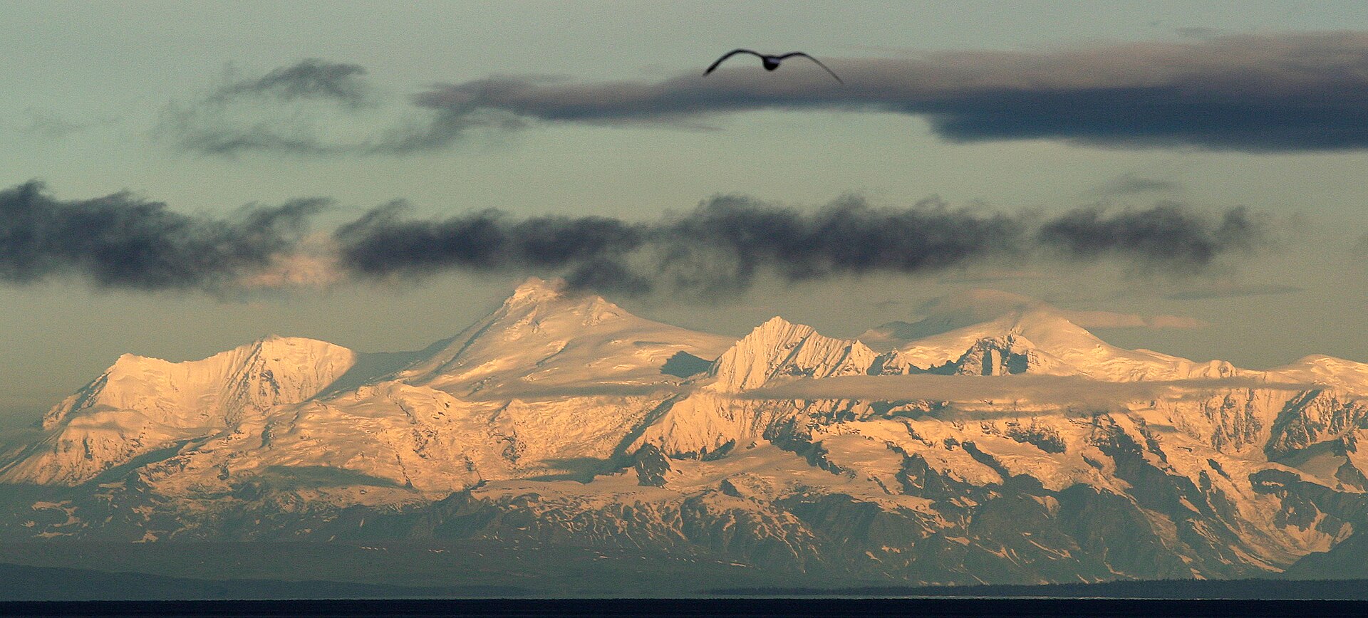 Mount Spurr and surrounding snowy peaks glowing at sunrise