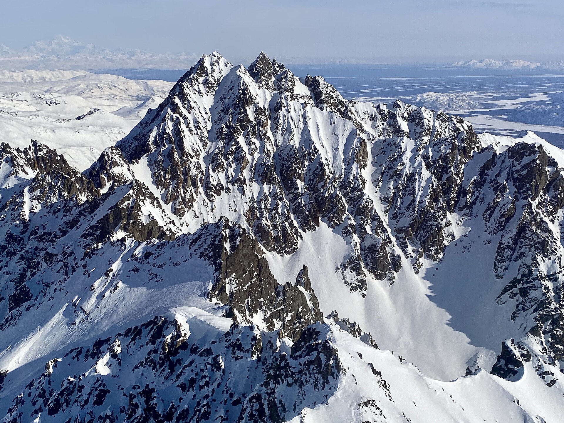 Jagged, heavily snow-covered summits of Alaska's Neacola Mountains