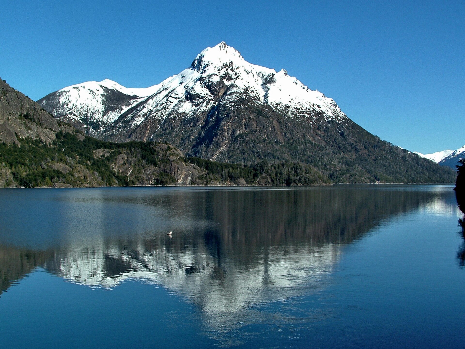 Le Cerro Capilla se reflétant dans l'eau bleue du lac Nahuel Huapi