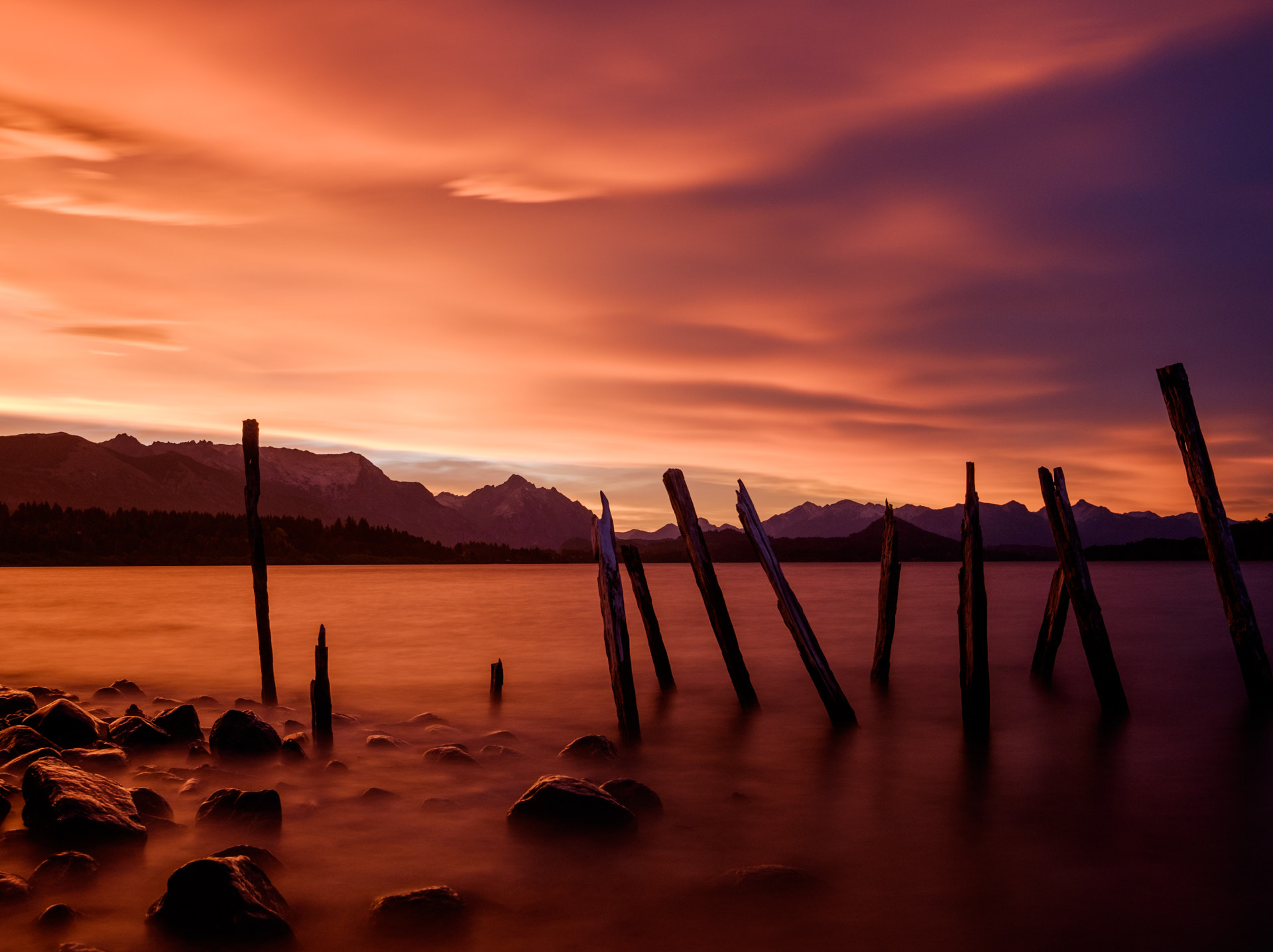 Un coucher de soleil orange et violet intense sur le lac Nahuel Huapi et les silhouettes des montagnes
