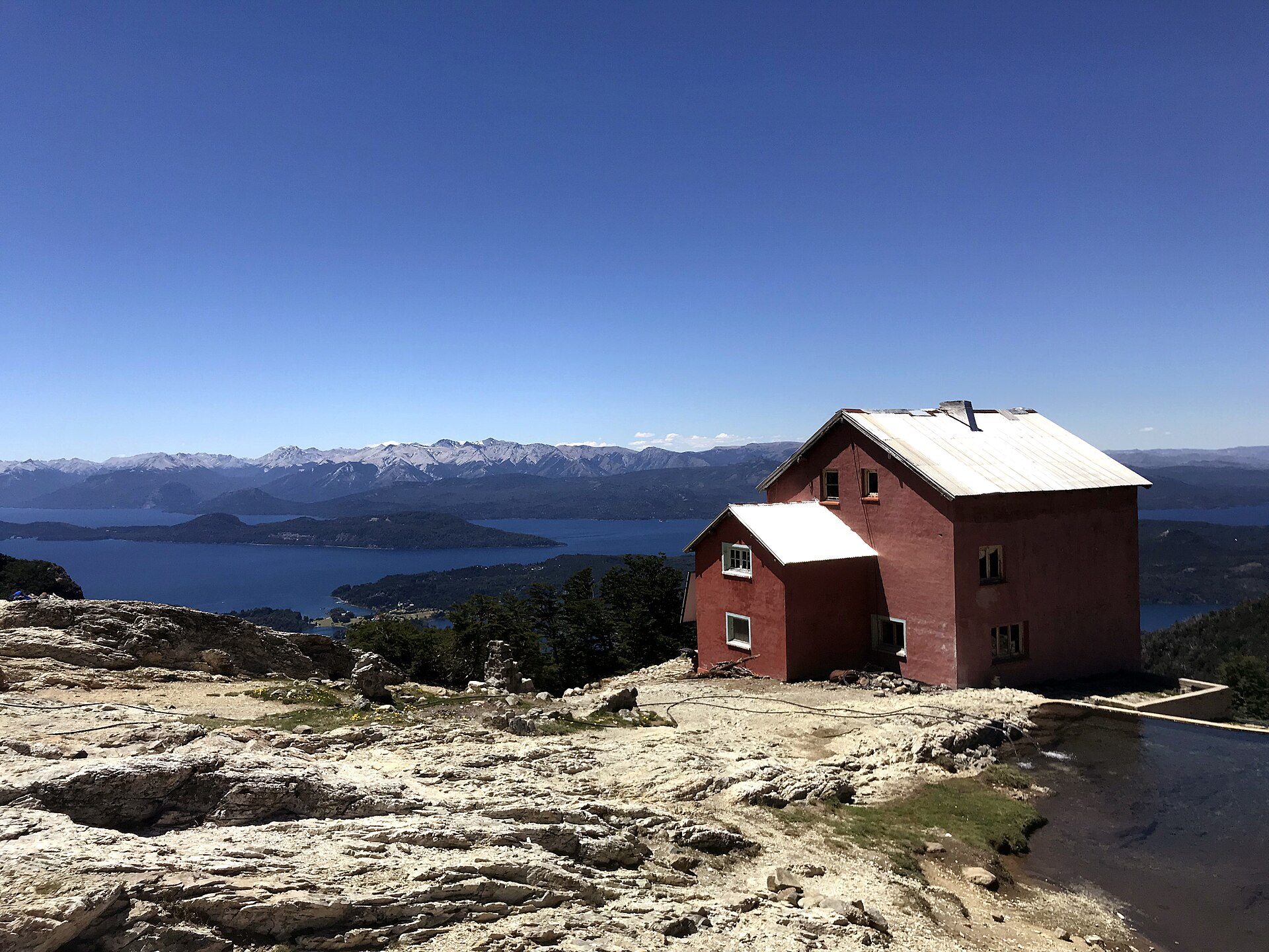 Le Refugio López, rouge, sur une pente rocheuse au-dessus du lac Nahuel Huapi