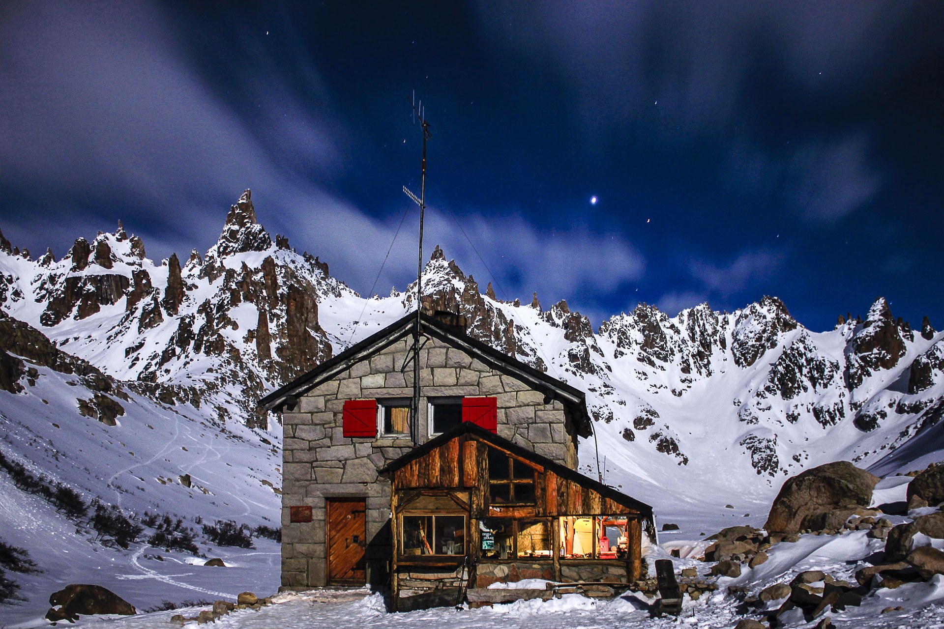 Le Refugio Frey illuminé la nuit sous des aiguilles de granite enneigées