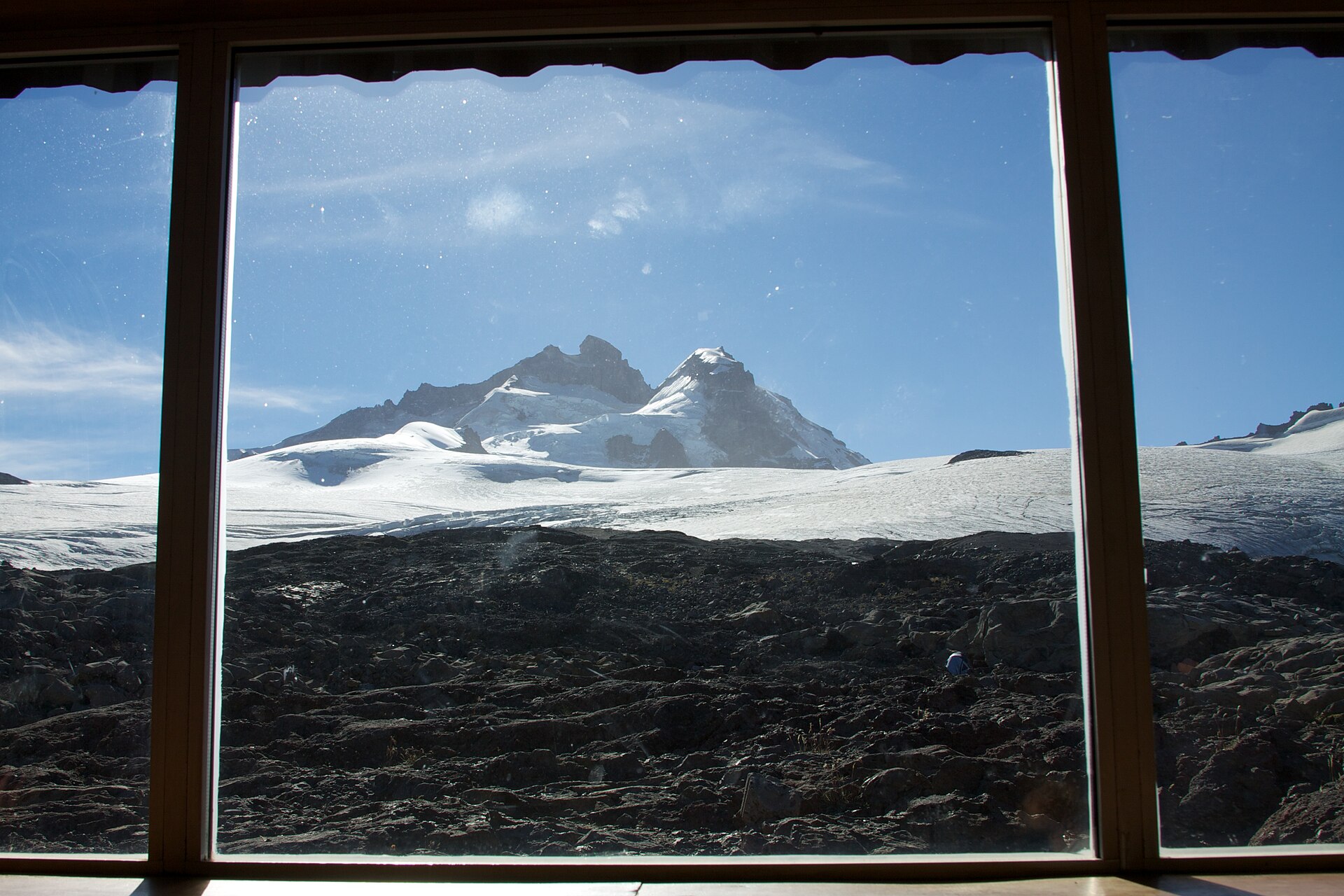 Le Cerro Tronador encadré par l'intérieur sombre d'une fenêtre de refuge de montagne