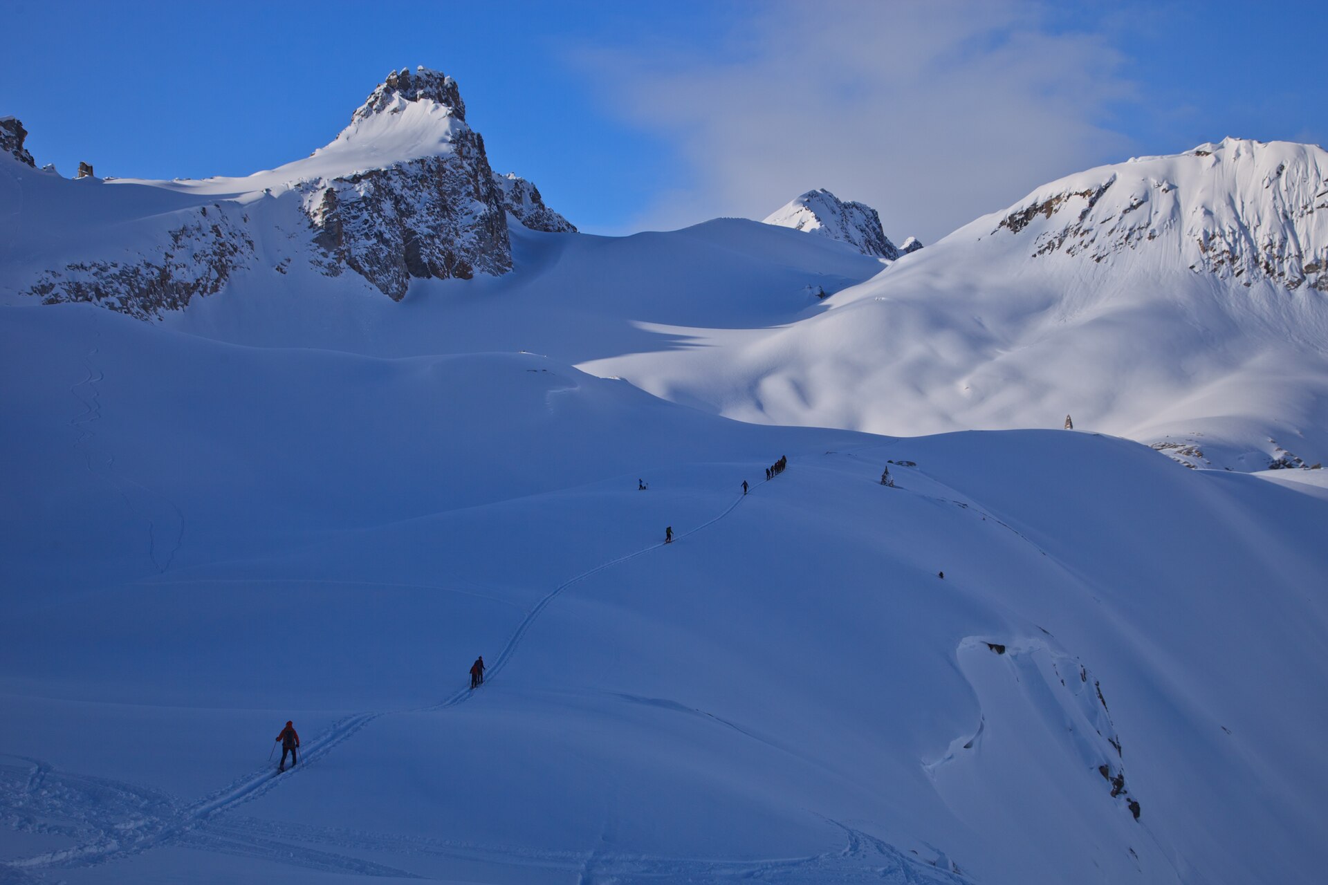 Des randonneurs à ski traversant un haut paysage enneigé en Colombie-Britannique