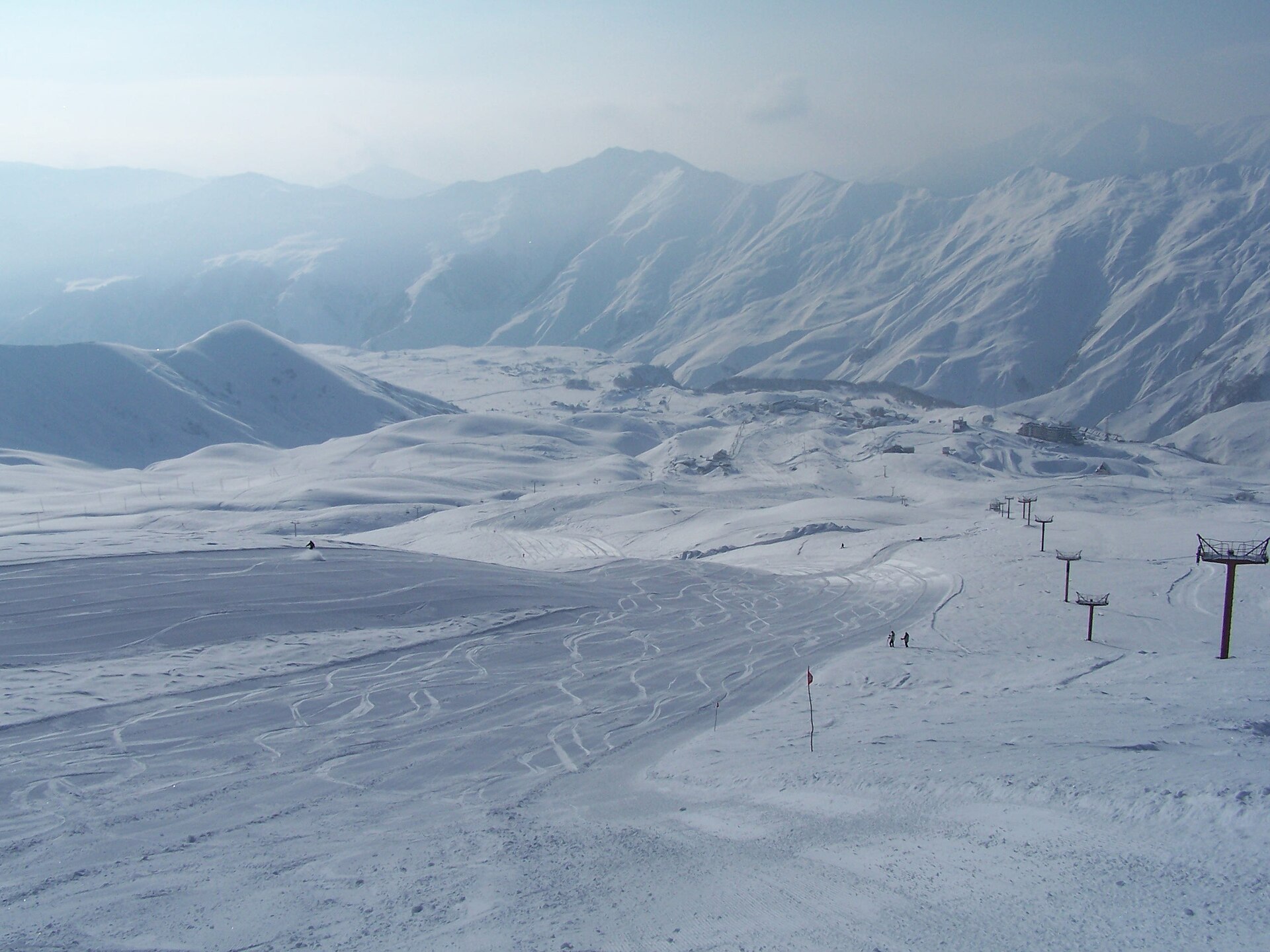 High view across rolling snowfields and steep Caucasus ridges at Gudauri