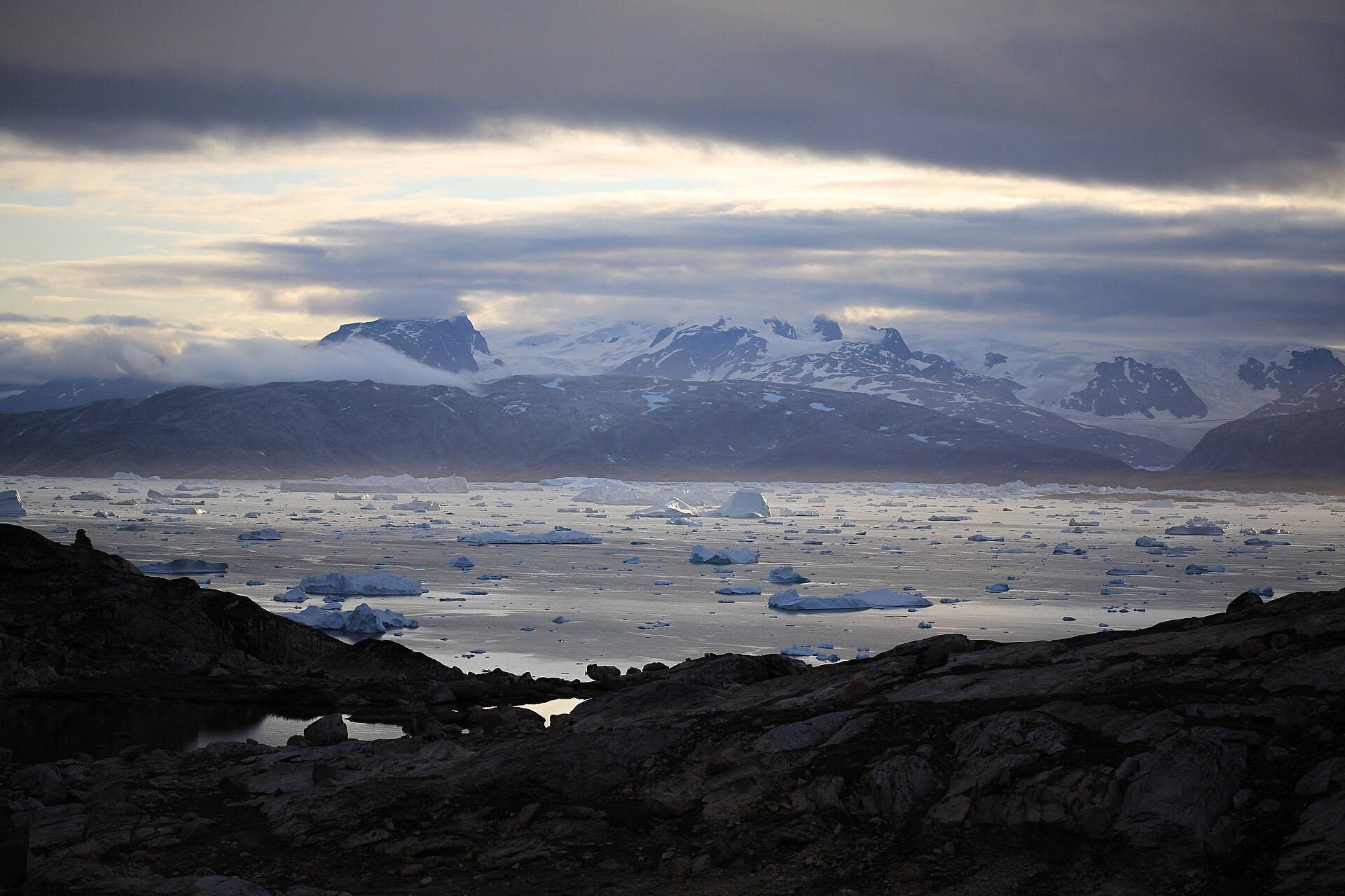 Sermilik Fjord with snowy mountains and the Greenland Ice Sheet in the distance