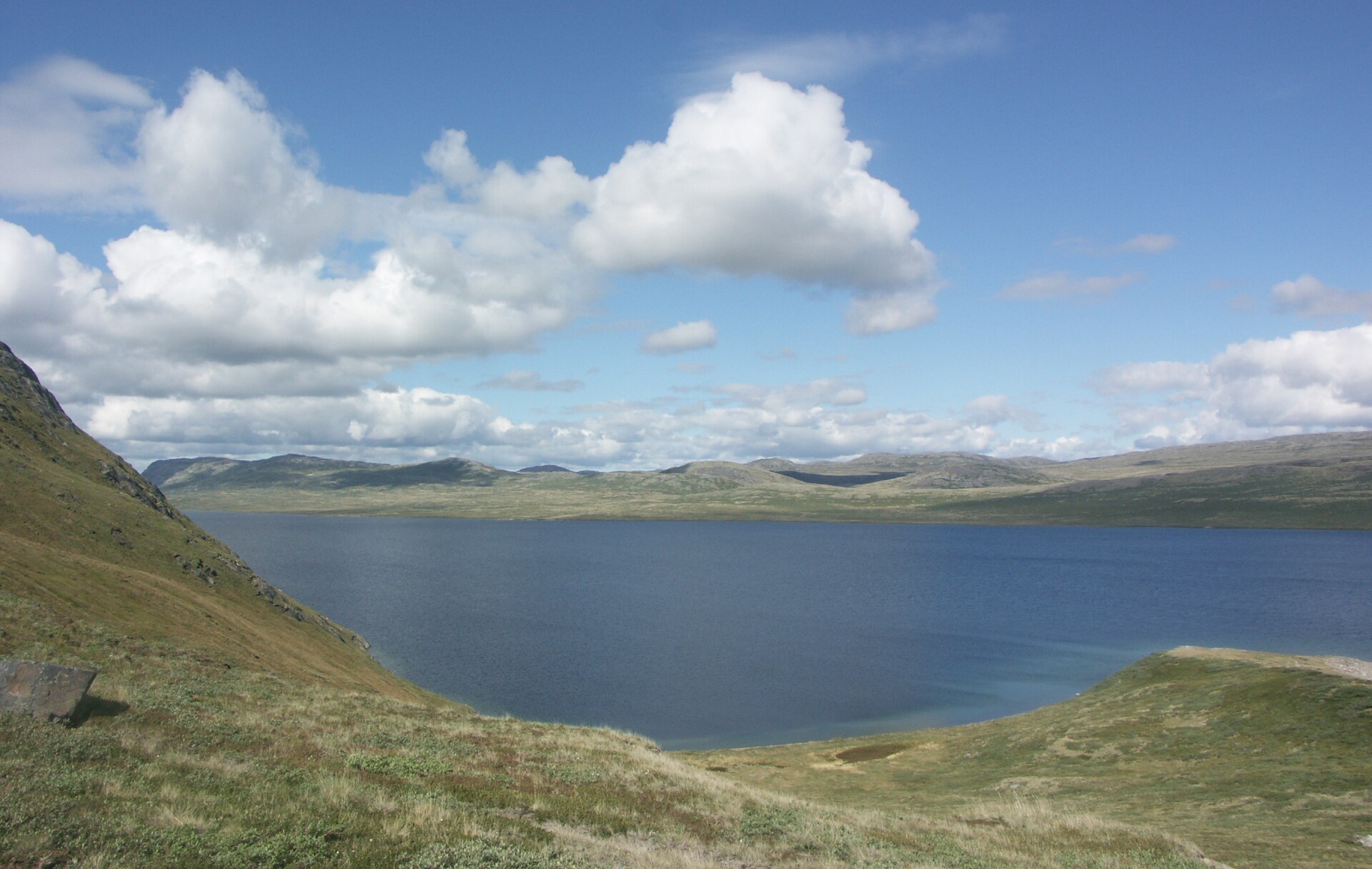 Turquoise Aajuitsup Tasia lake surrounded by bare alpine mountains in West Greenland