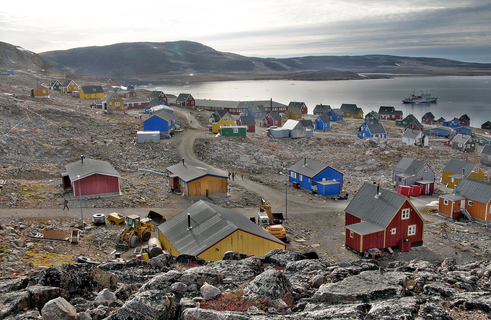 Colourful houses of Ittoqqortoormiit beneath rounded mountains beside Scoresby Sound