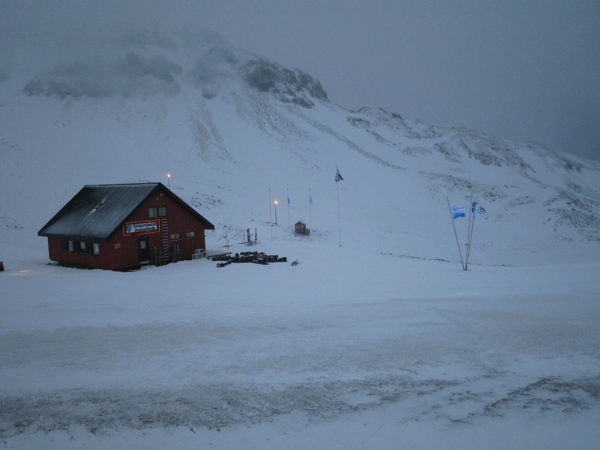 A ski-area building beneath a stormy snow-covered Eastfjords mountain
