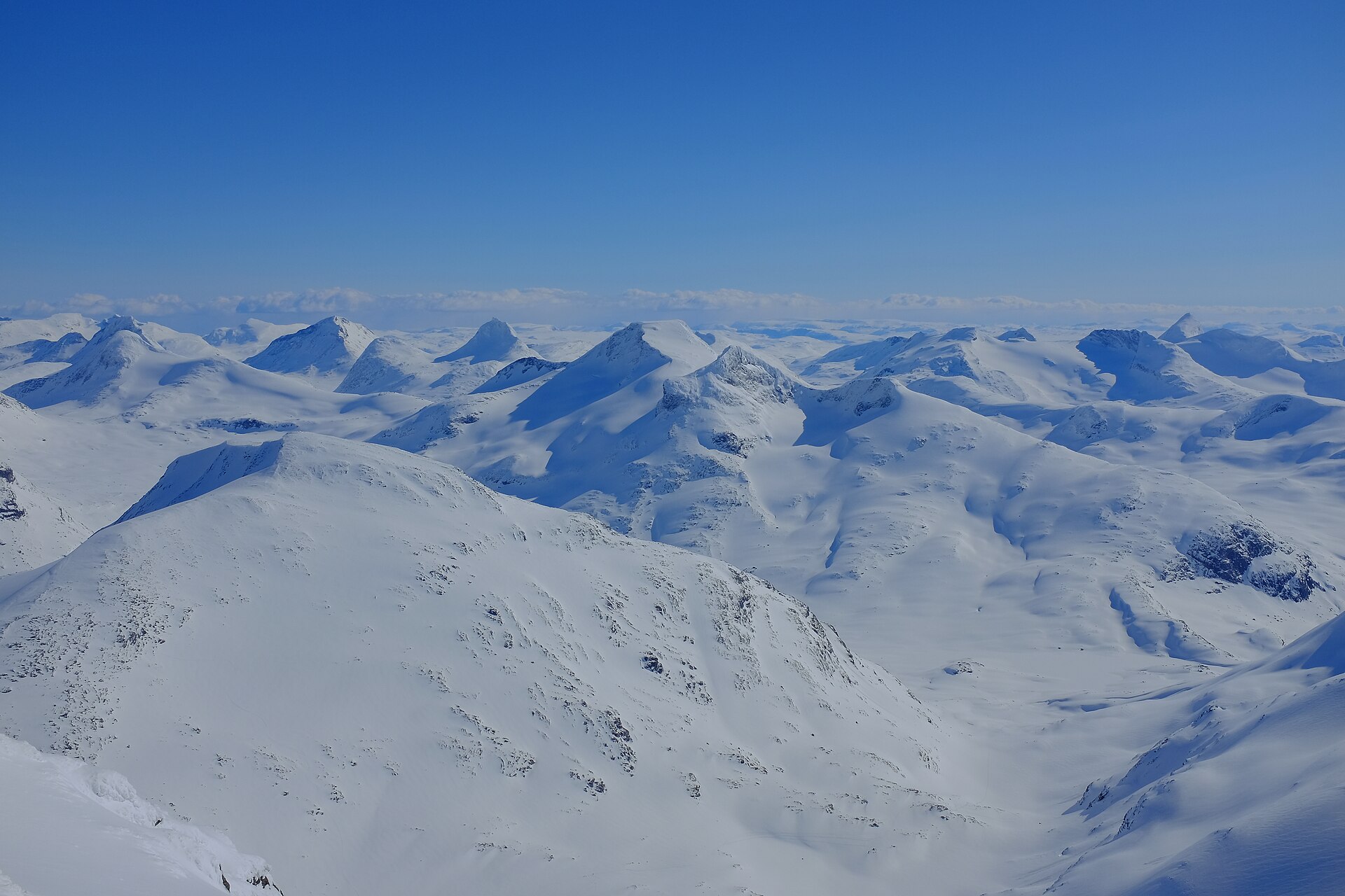 Snow-covered Hurrungane and southwestern Jotunheimen seen from Storebjørn