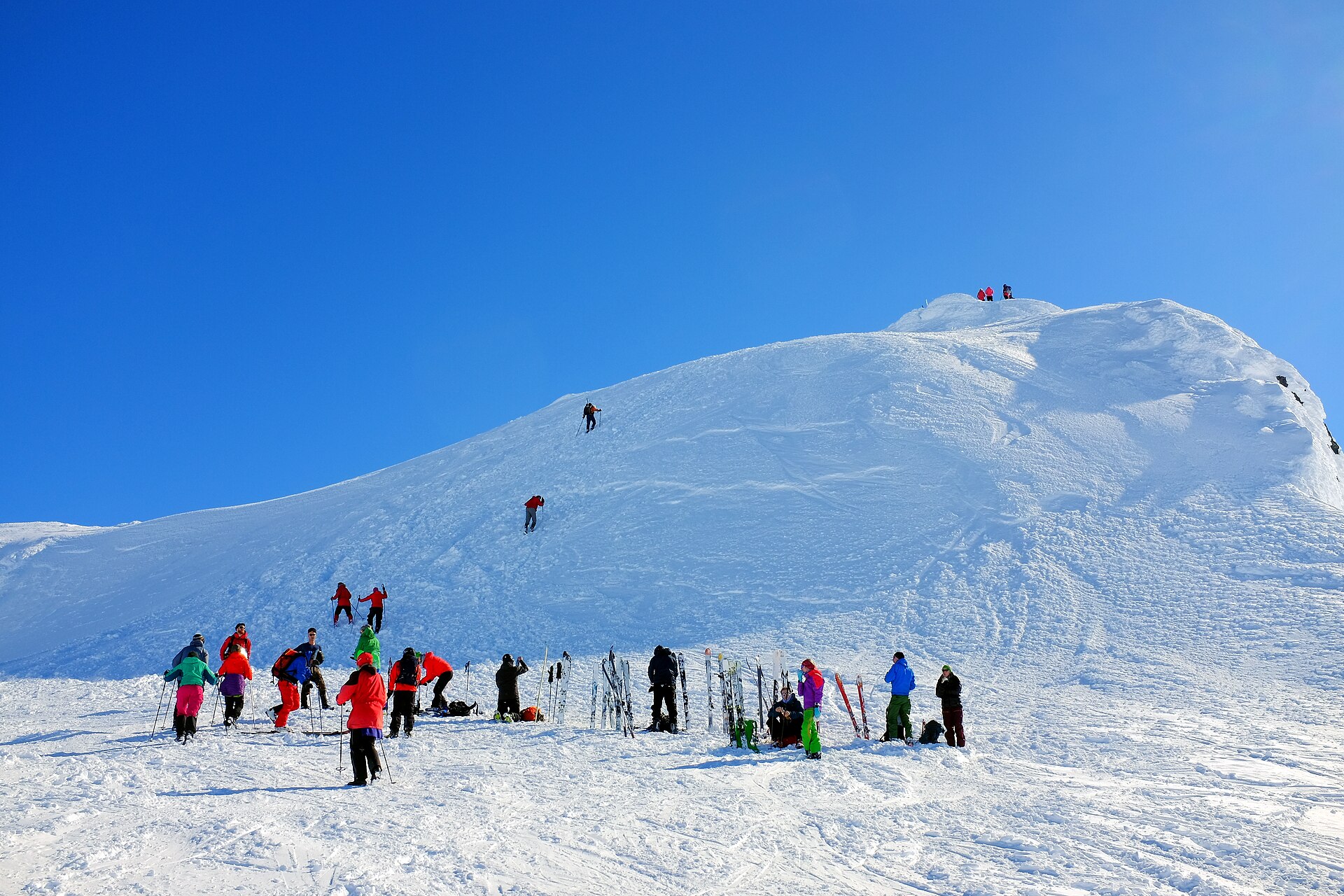 Ski mountaineers climbing the final steep section below Storebjørn's summit