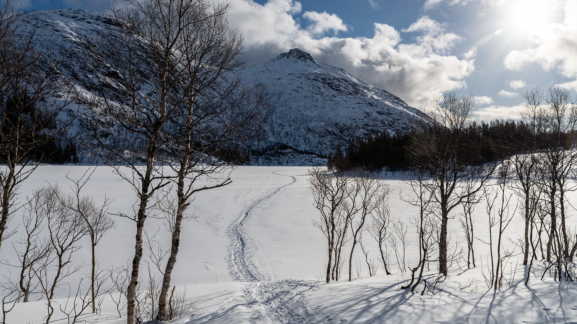 Frozen Øvre Svolværvatnet beneath steep snow-covered Lofoten mountains