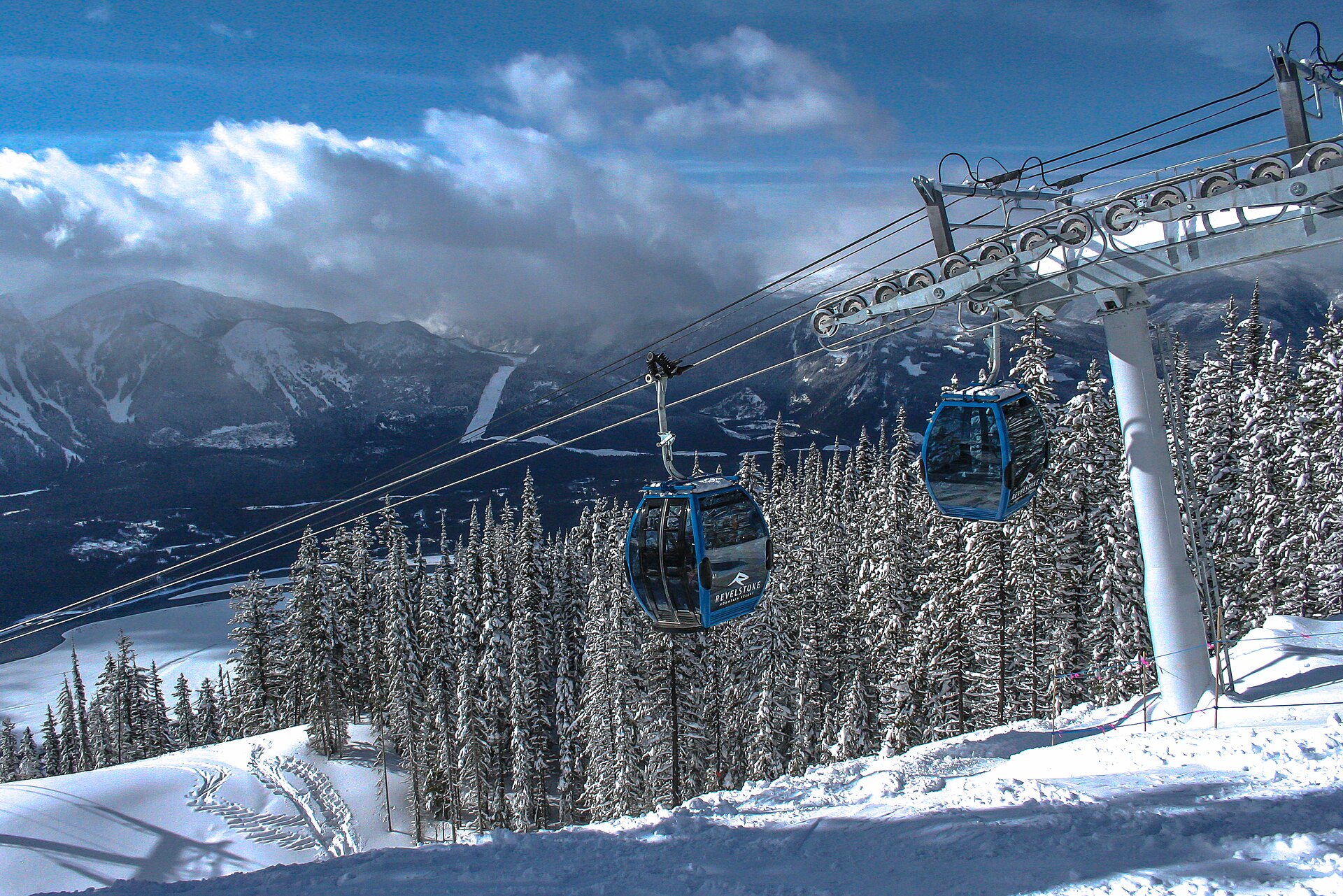 La télécabine de Revelstoke au-dessus d'une forêt enneigée, montagnes à l'arrière-plan