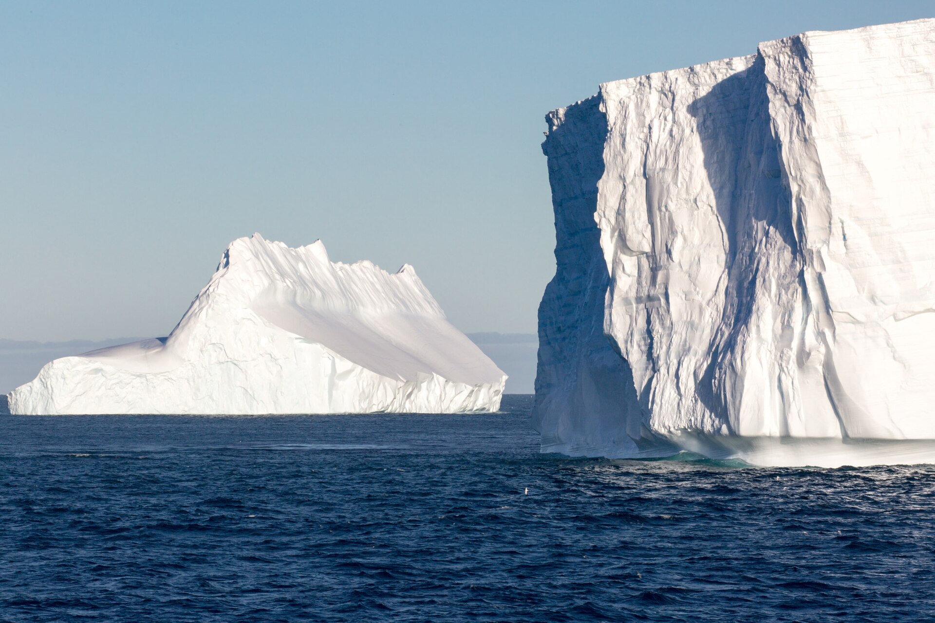 A tabular iceberg and sculpted ice floating off South Georgia
