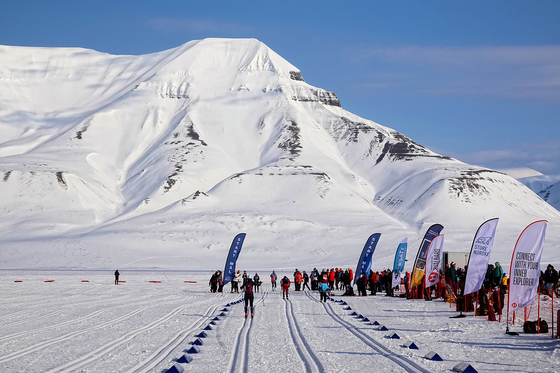 Skiers in Adventdalen below the snow-covered mountain Hiorthfjellet