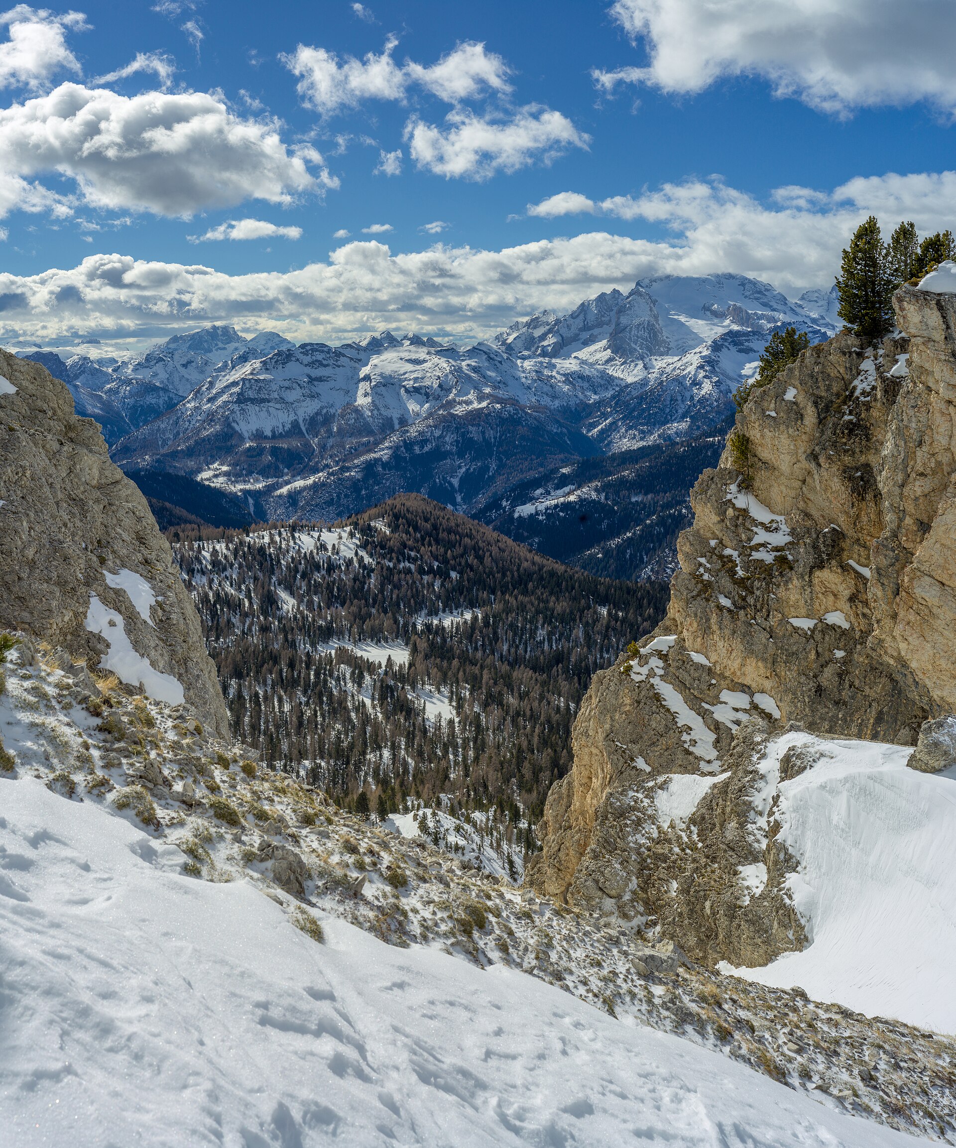 Un couloir enneigé des Dolomites encadrant la Marmolada au-dessus de la vallée de Fodom