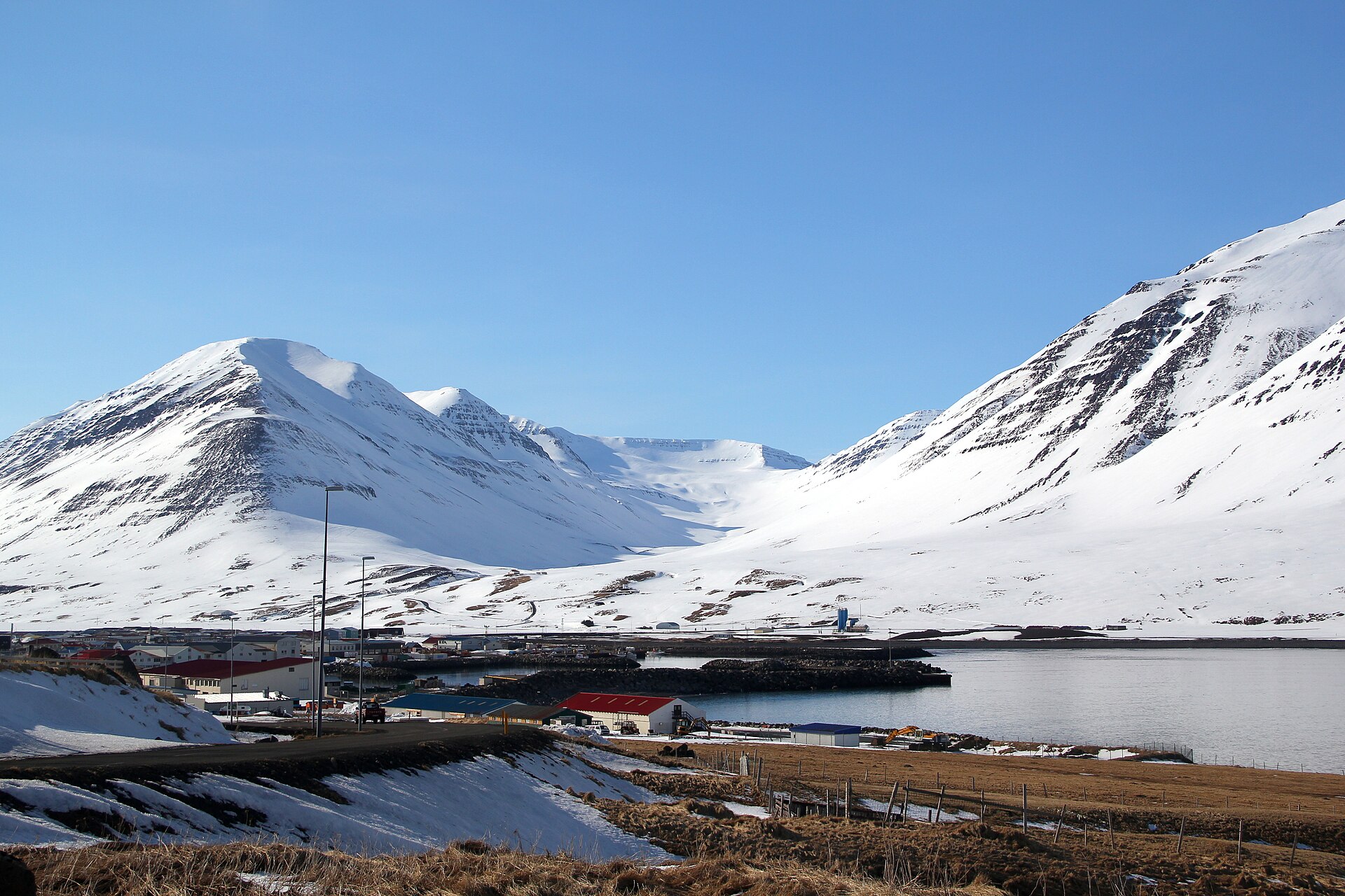Snow-filled mountains rising directly behind Ólafsfjörður