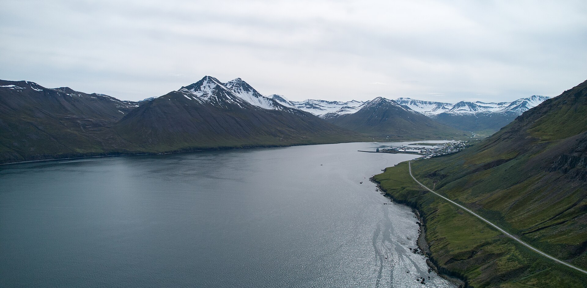 Aerial view along Siglufjörður toward its snow-covered mountain head