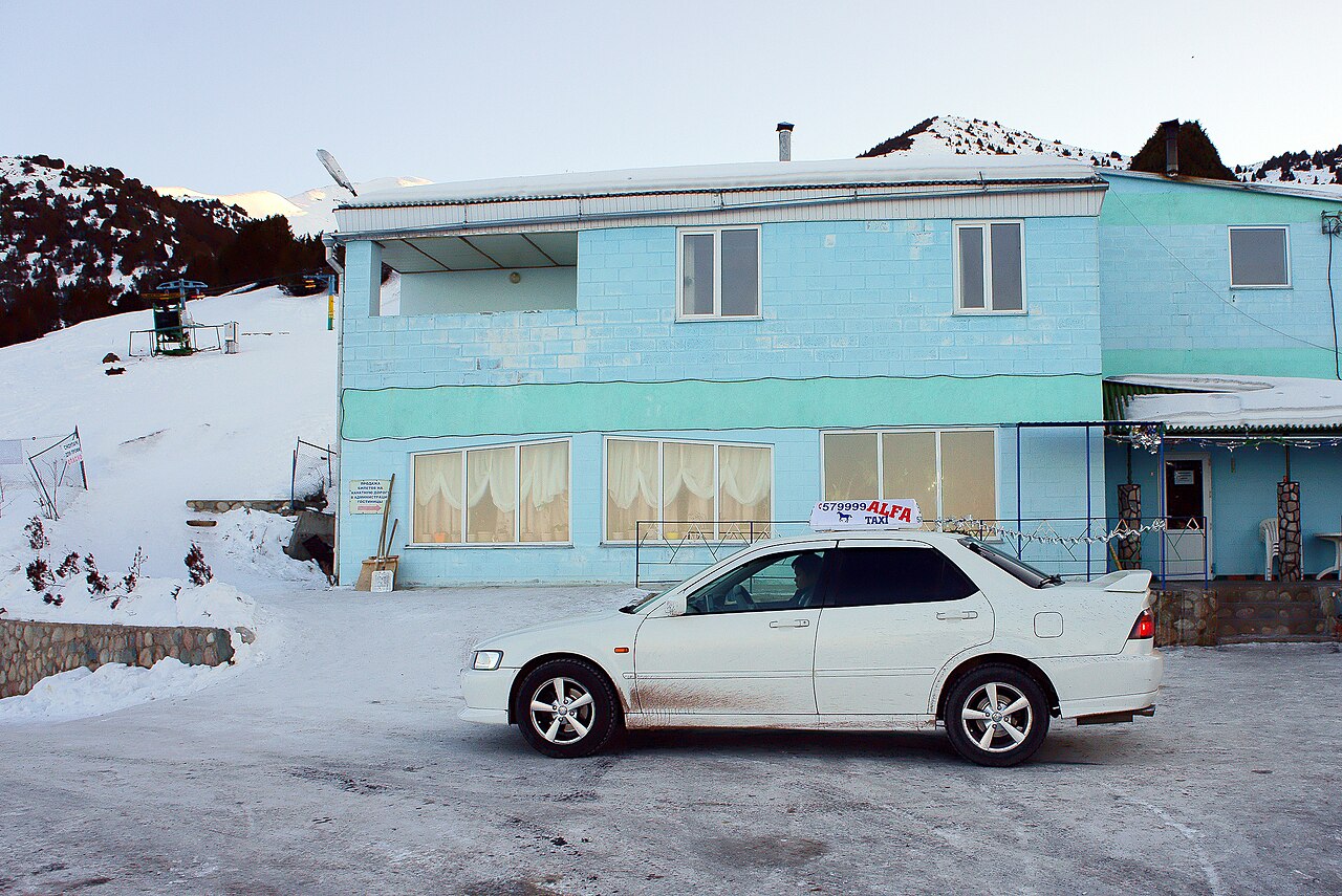 A simple lodge building beside a snow-covered road in Ala-Archa