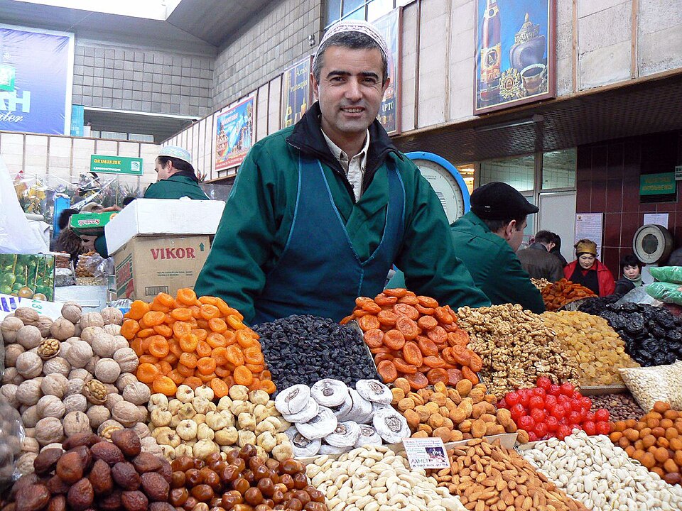 A vendor surrounded by nuts, dried fruit and spices in Almaty's Green Bazaar