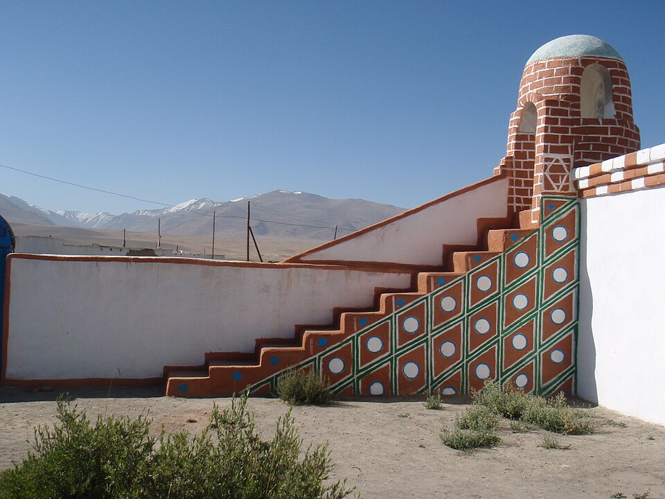 The small, brightly decorated mosque at Alichur against barren Pamir mountains