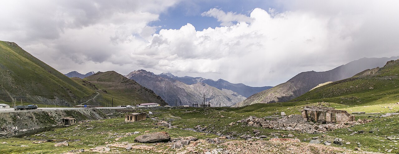 The broad Töö Ashuu pass corridor winding through high green mountains