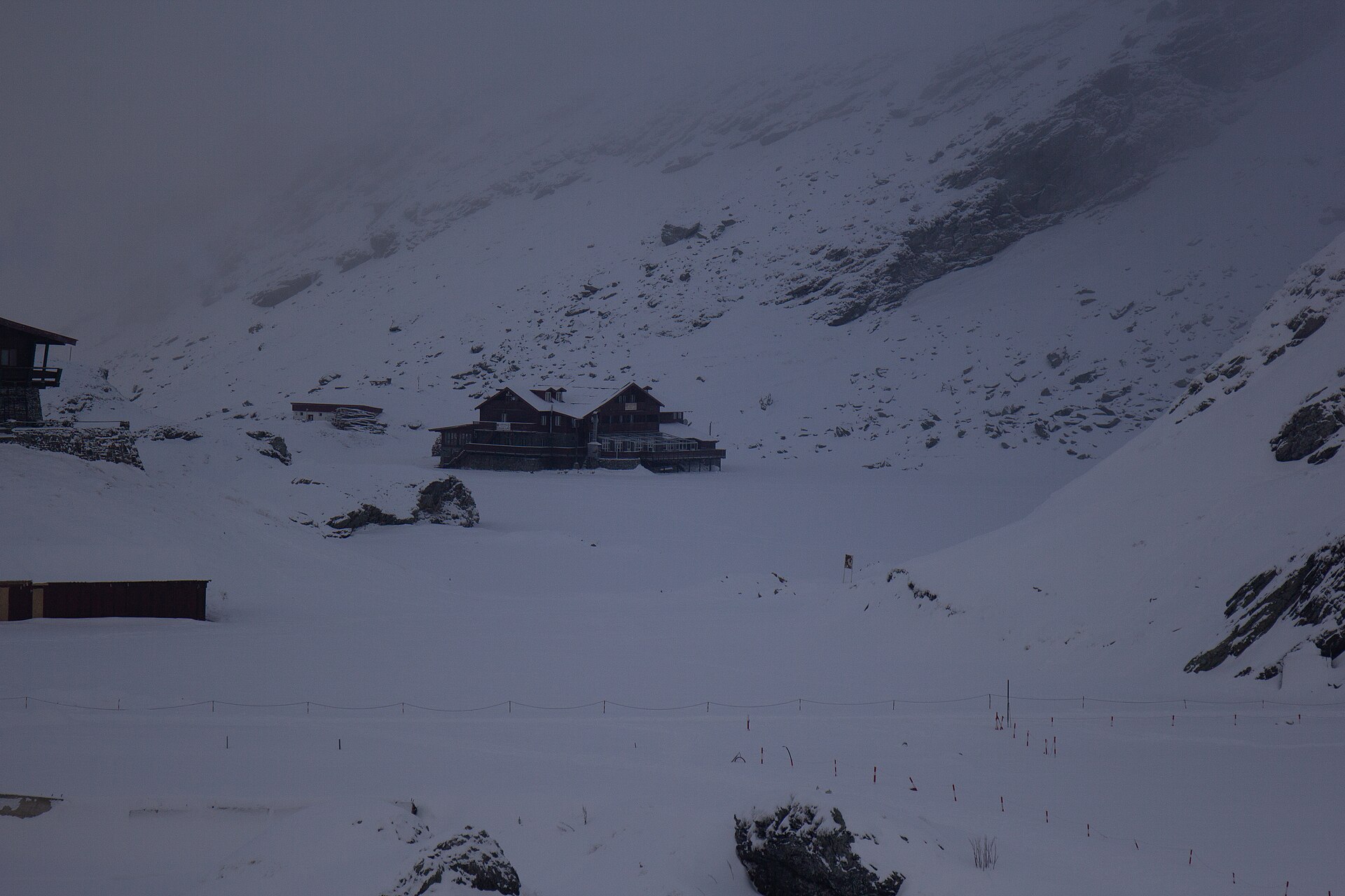Bâlea Lake cabins surrounded by deep snow beneath steep slopes