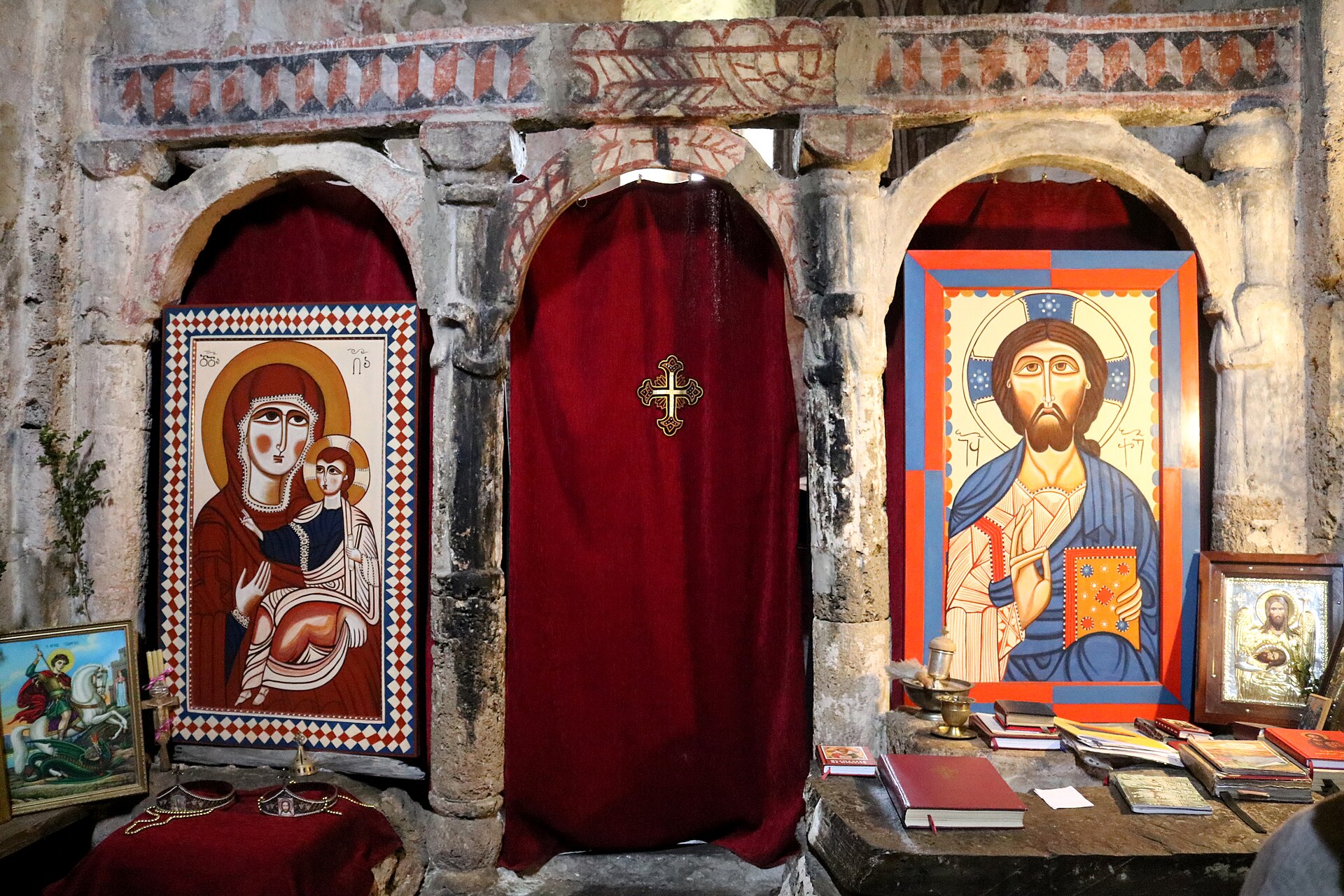 Painted icons and a red curtain inside Lamaria church in Ushguli