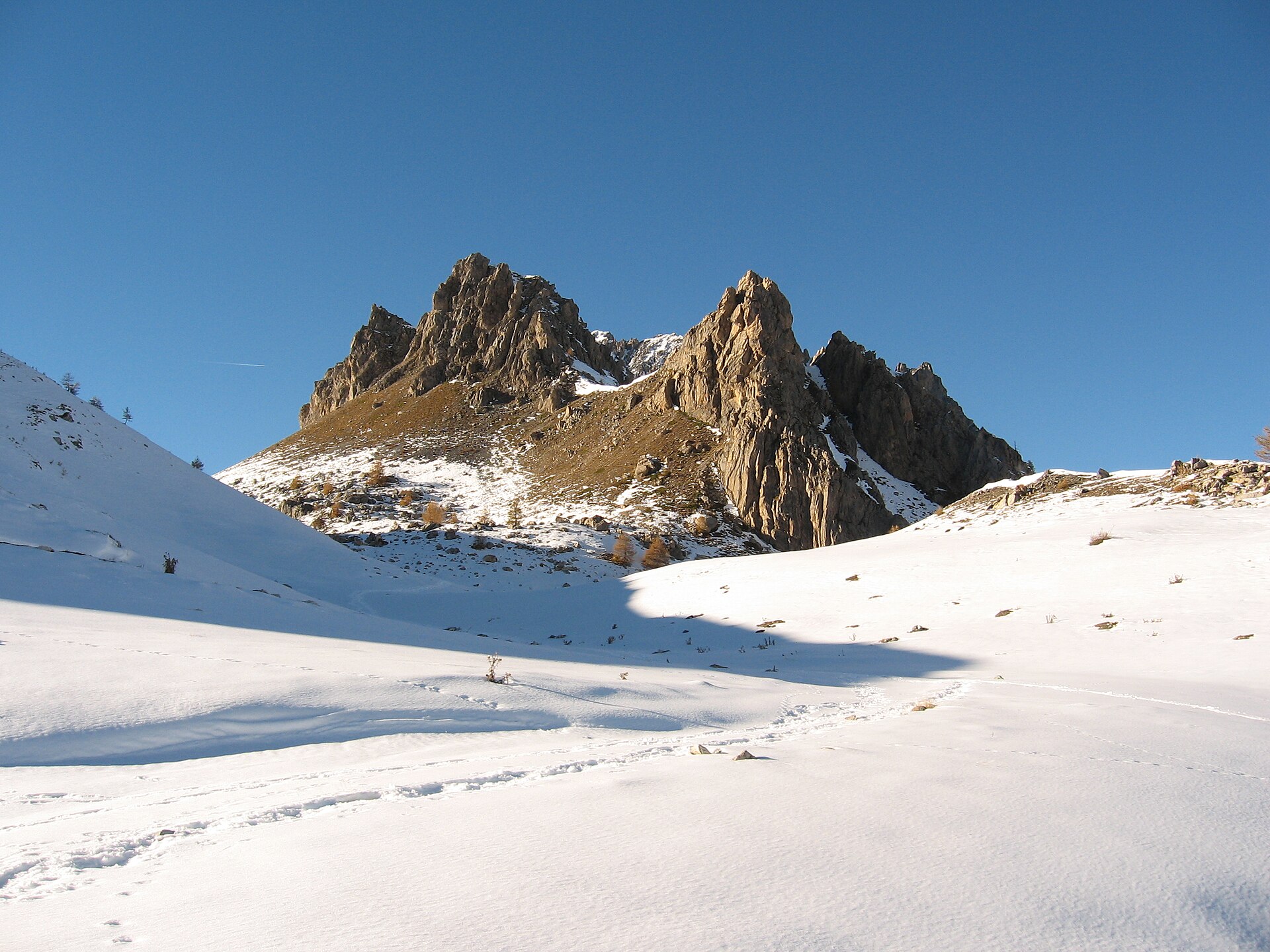 Jagged rock towers rising from snow in Valle Maira