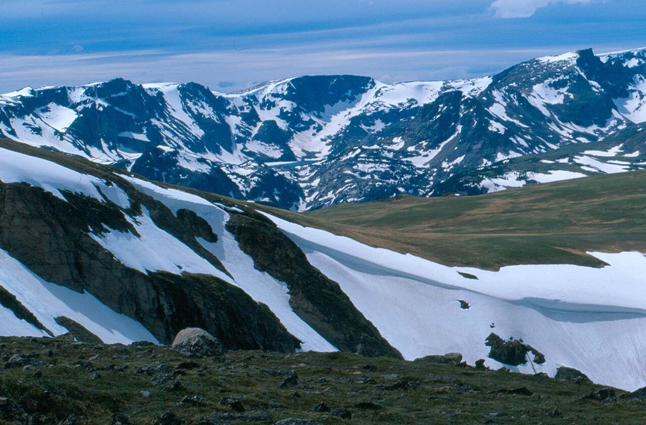 Snow-covered Beartooth Mountains beside the highway in early summer