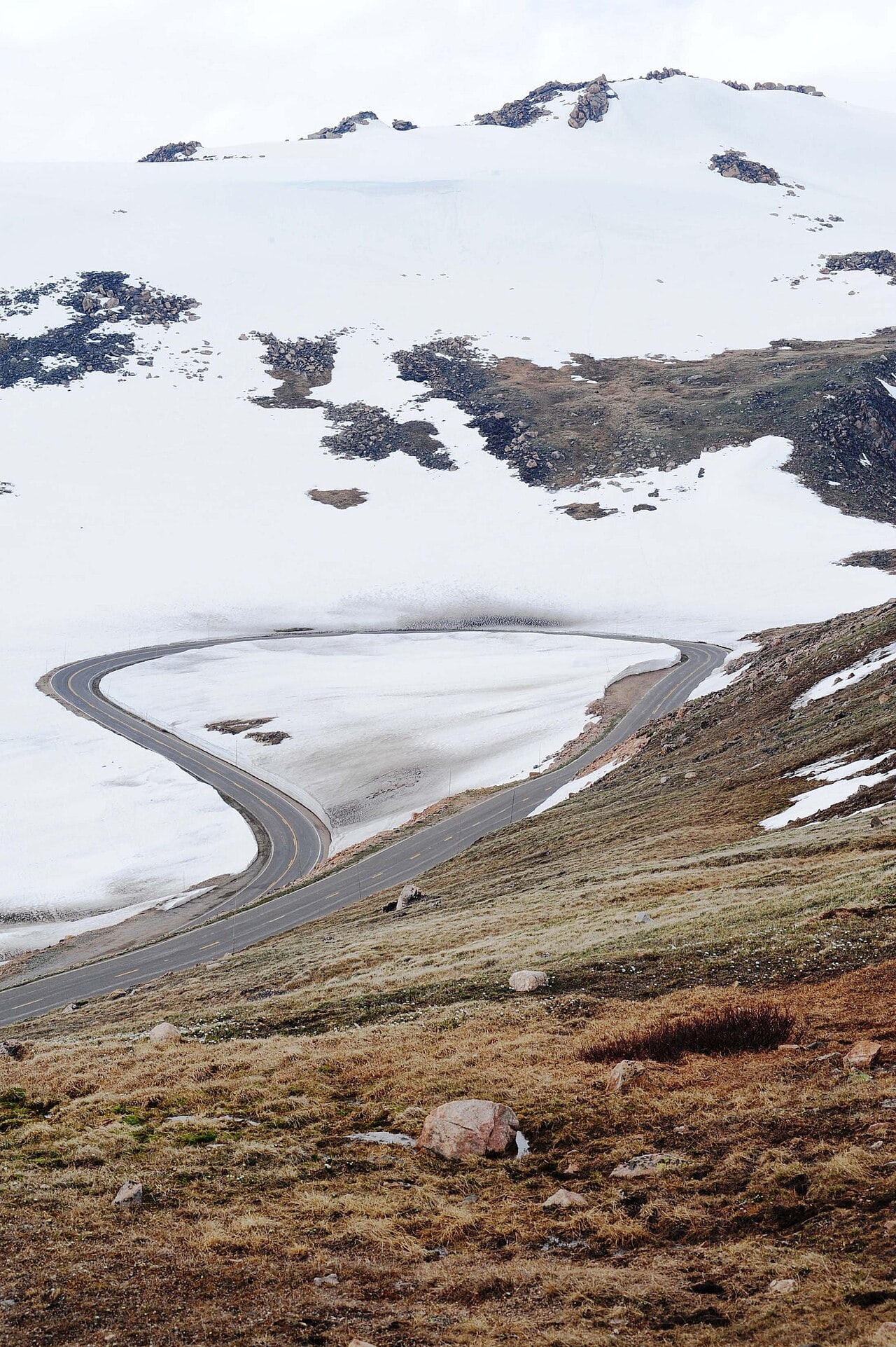 A hairpin bend on Beartooth Highway surrounded by deep snow