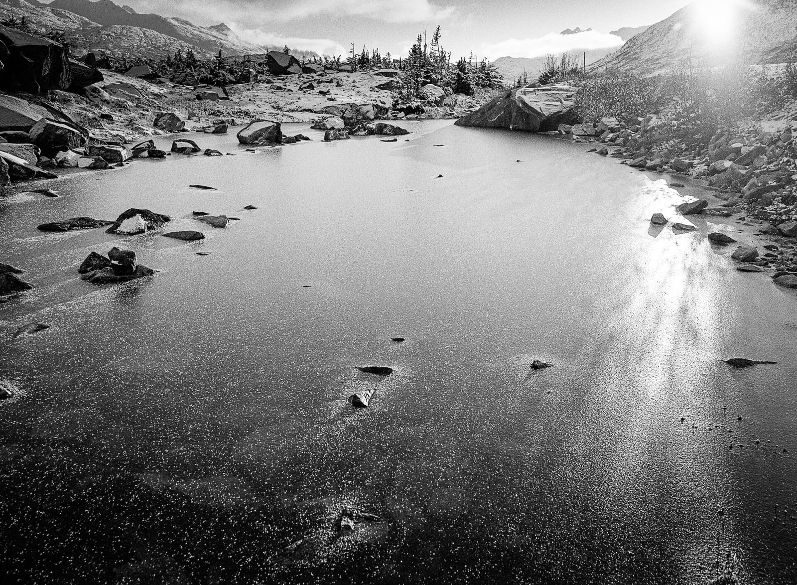 New ice forming on a lake beneath the mountains of White Pass