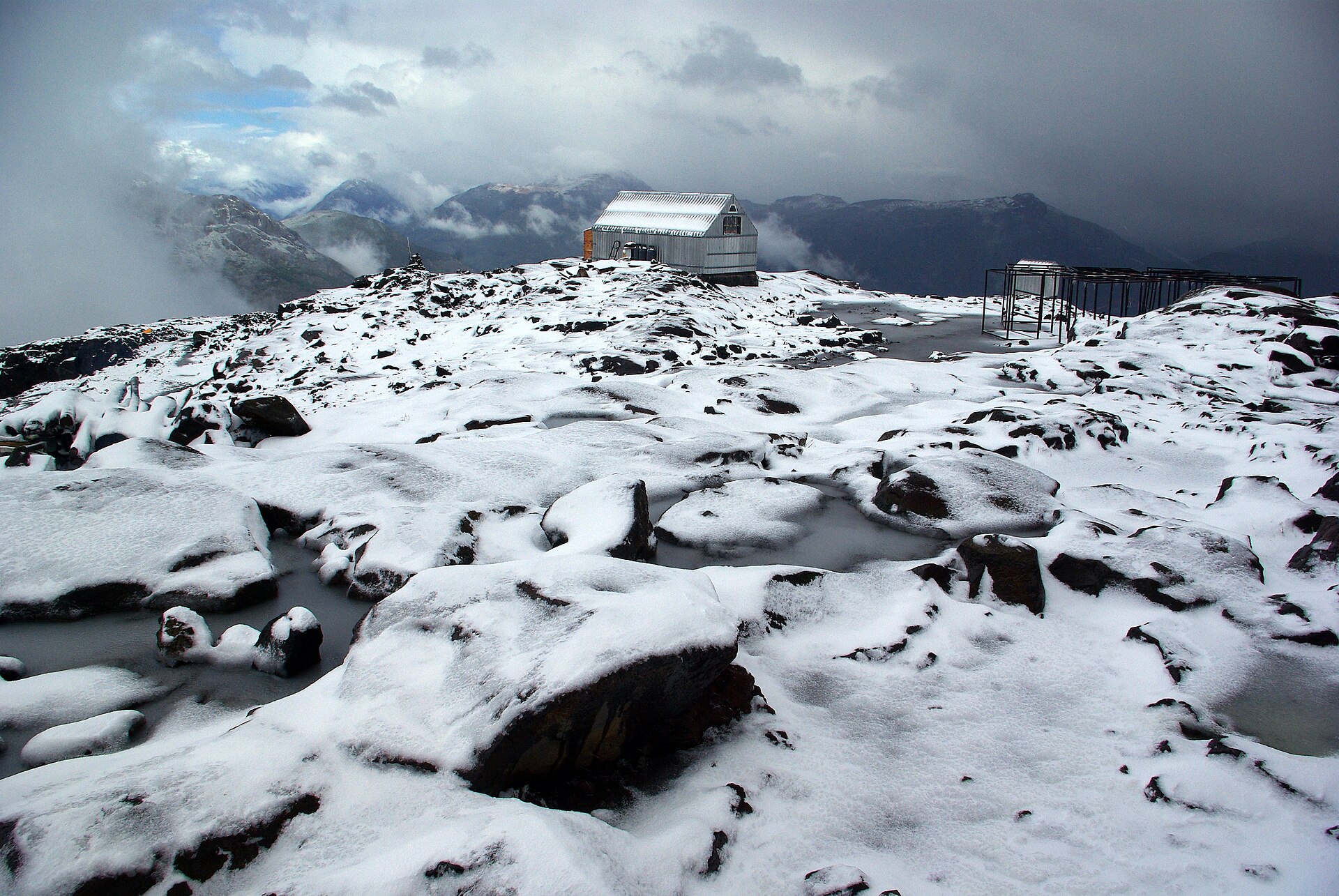 Refugio Otto Meiling standing on a snowy ridge high on Cerro Tronador